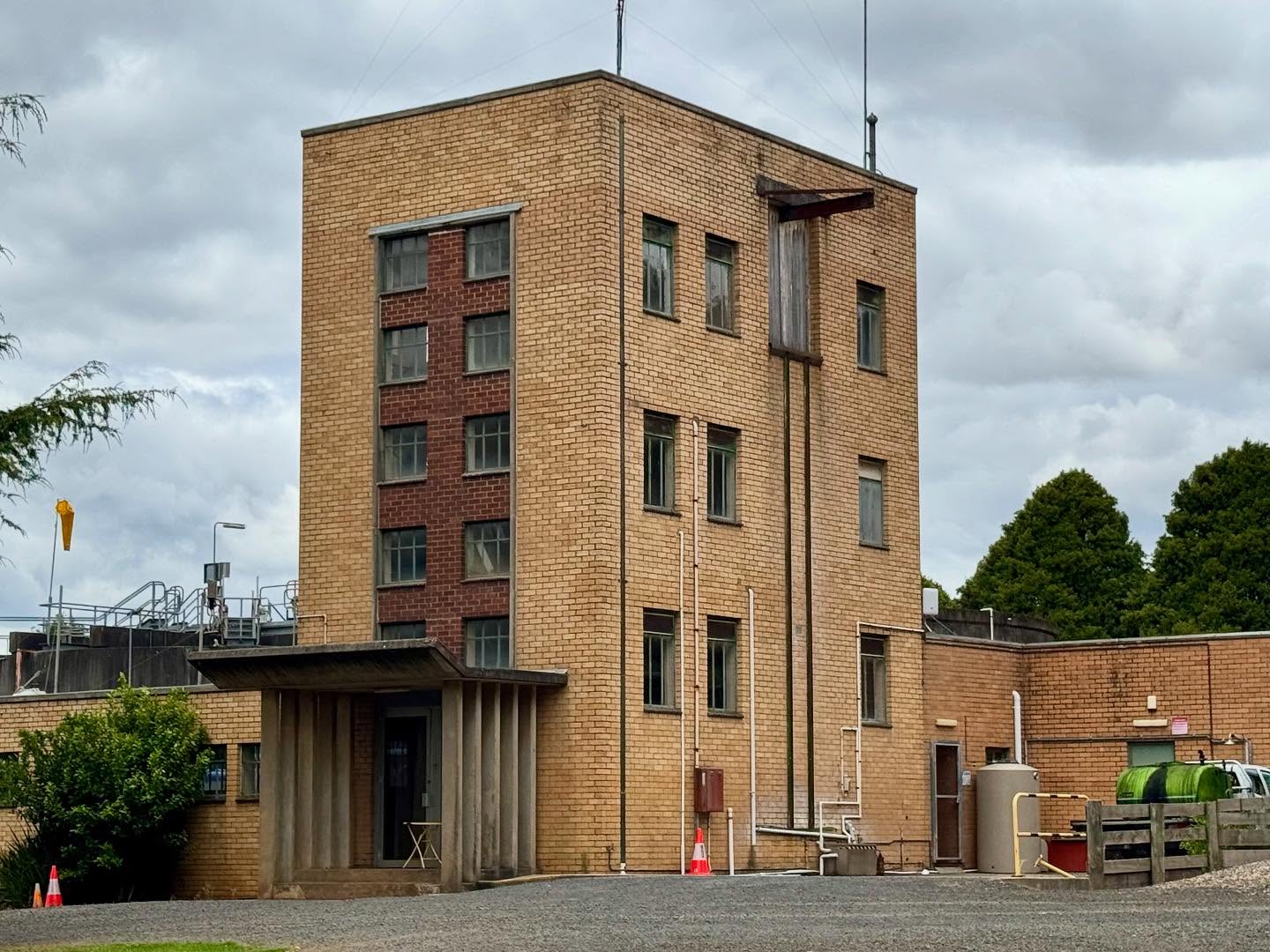 Do I sense some Dudokian industrial functionalism in the bush? Pull over! Cream brick parapeted volume with front red brick panelling( concrete edging). Punched steel-framed openings. Trabeated concrete porch with ‘angled up’ roof. Apparently, late 1950s build and designed by a consulting engineer (Ronald M. Scott) for the Leongatha Water Walks Trust as a water purification plant. Looked abandoned/peopless.