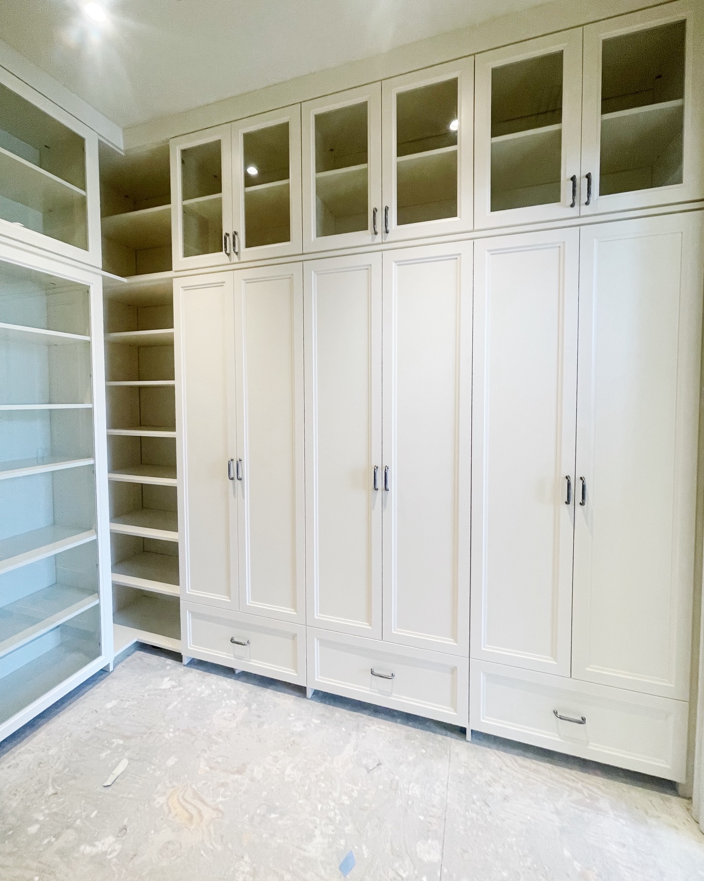 This storage closet is coming to life with carpet, counters & base molding next.
When a space needs to both hide + display, here’s how I approach it:
• Closed cabinetry → for the items you don’t want to see every day
• Glass focal cabinets & uppers → keeps things feeling light while still giving you a display moment
• Open shelving → easy access for frequently used items
• counter height drawers → giving a drop zone area & in this case for a printer
The goal is to store most but make it intentional 🤍✨
Your friend, the custom closet designer
Save this for your future storage planning😉