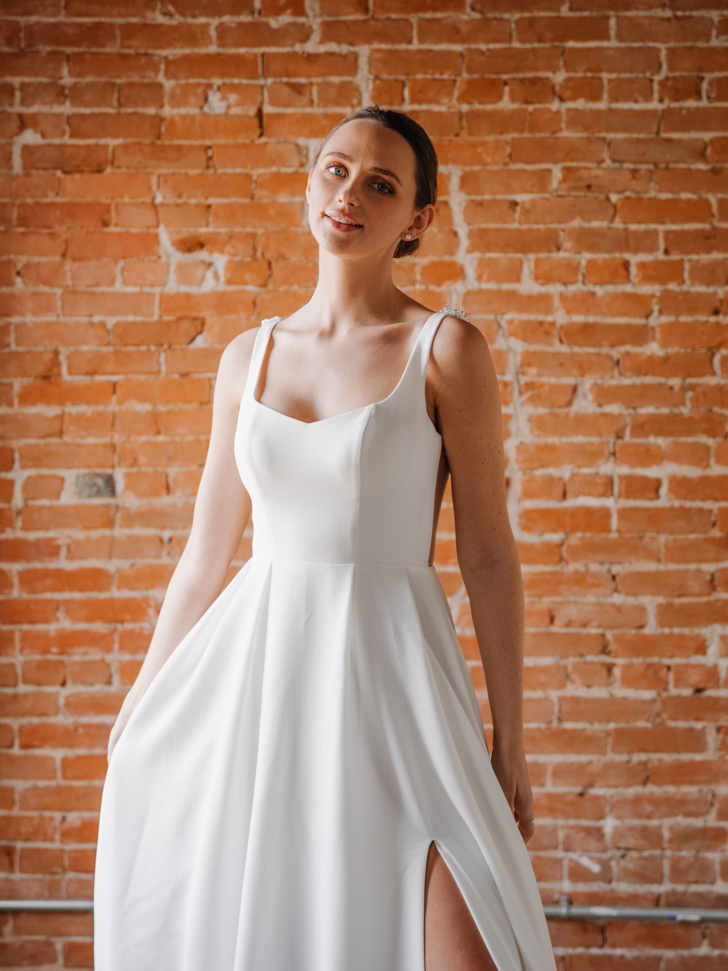 If Zendaya just gave us a masterclass in “timeless but make it cinematic” in The Drama, then consider this your sign…
Our version? Same energy. Different muse. 🤍
A sculpted crepe moment with a soft scoop neckline and a slit that keeps things just a little unexpected make this gown so chic and timeless. Effortless, refined, and made for the bride who wants classic without feeling predictable.
Melanie | N242121