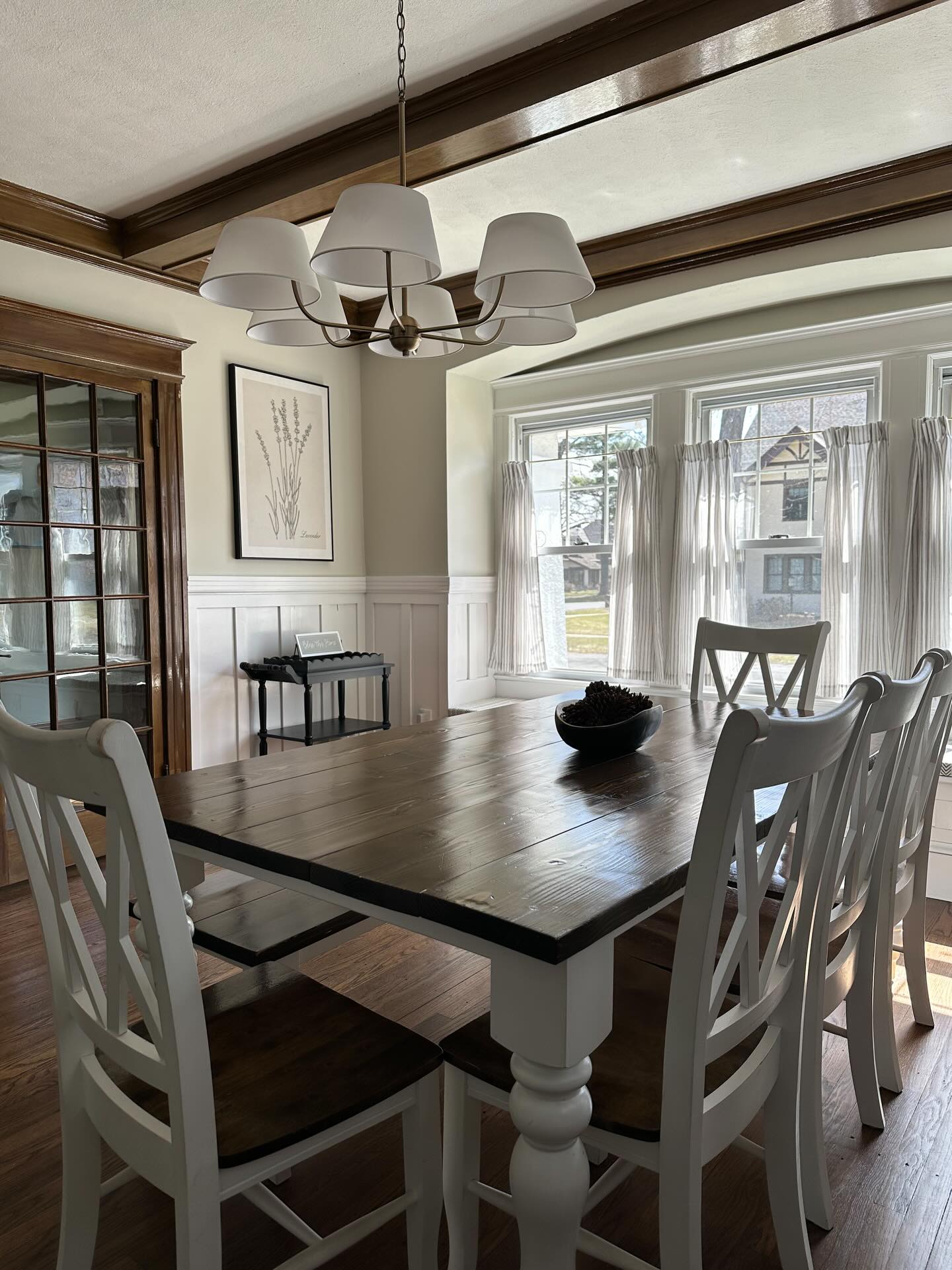 Before and after of the dining room in my early 1900’s project. I’m generally one to keep original woodwork, but painting the wainscoting was not only far more cost effective, but it also helped create a much more inviting space for this family (it also was one of the only spaces left in the home that didn’t already have painted woodwork, so it was feeling really disjointed from the rest of the house). I DID keep the wood beams and the French doors the original stain and created a custom stain for the floors to match them to the original woodwork.
.
#classicinteriors #diningroommakeover #timelessinteriors #wainscoting #oldhomes