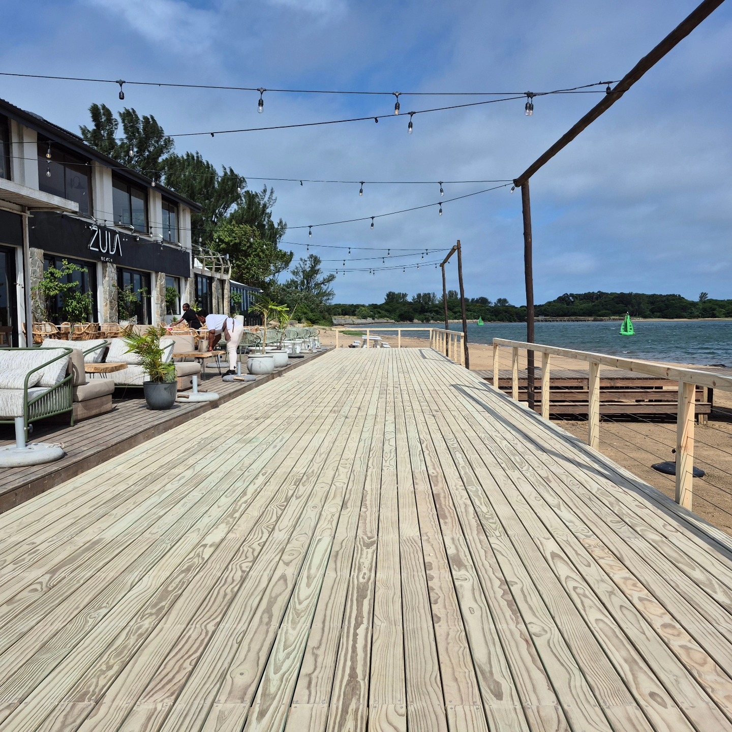 Expanding the Space at Zula Beach 🌴🌊
We recently returned to Zula Beach Bar to complete another deck extension, helping them create more usable space closer to the beach—perfect for busy days and events.
🛠️ Built on Sand: This extension came with a unique challenge: building directly on the beach. To make sure the structure remained stable and didn’t shift over time, we poured concrete pads beneath each post to support the deck and prevent sinking.
📐 Tiered Design: The new deck was built one level lower than the original to work with the natural slope of the sand and keep the view from the restaurant open and uninterrupted.
🔗 Unobstructed Views: We installed a wire rope balustrade around the perimeter of the new section to provide safety without blocking the ocean views.
🎧 DJ Booth Relocated: As part of the extension, we carefully deconstructed the existing DJ platform and reassembled it at the end of the new deck, keeping it front and centre for events while maintaining the clean flow of the new layout.
📲 Need a deck that works with your space? We specialise in smart, custom timber builds for every setting.
📍 Zula Beach and beyond.
📞 072 620 1486
🌐 www.mistymountaintimber.com
📧 mistymountainsa@outlook.com
Swipe to see how the extension fits into the bigger picture.
#BeachDeck #CustomTimberWork #WireRopeBalustrade #ZulaBeach #DeckExtension #OutdoorDesign #MistyMountainTimberworks