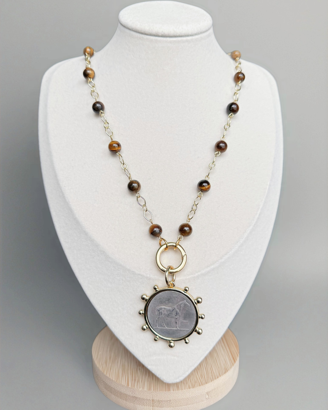 Souverain Équestre — Tiger Eye coin pendant necklace: bold structure, quiet shimmer. Hand‑pinned tiger eye beads, 18k gold‑filled push gate, and a bronze horse coin for movement and strength. Adjustable length for layering or a bold standalone look. Link in Bio #TigerEye #HandcraftedJewelry #QuarryAtelier #EquestrianJewelry #GoldFilled #StatementPiece