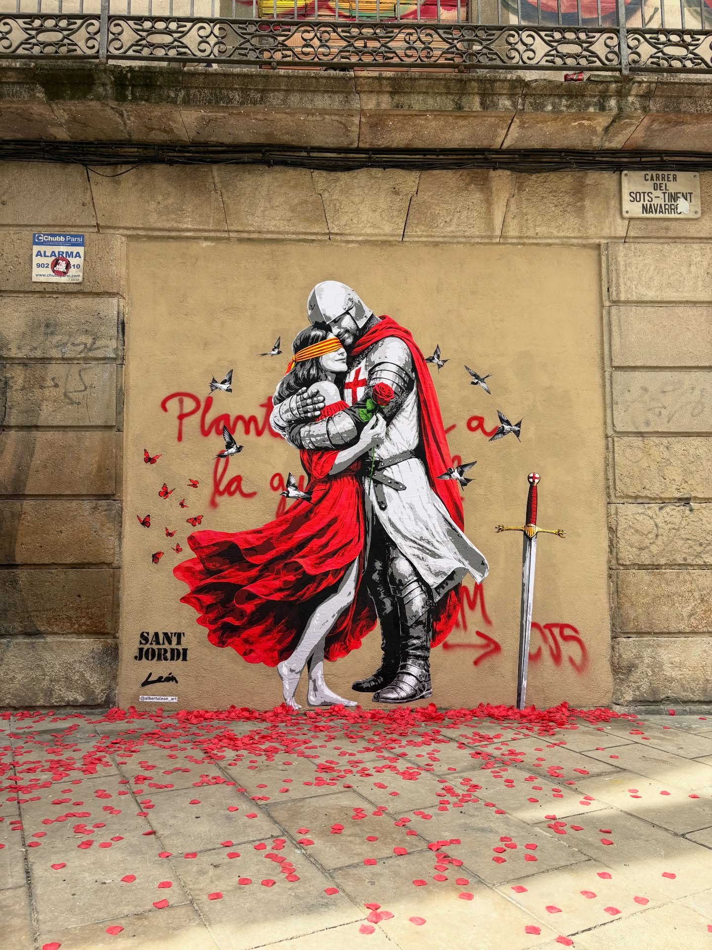 Morgen 23 april wordt Sant Jordi gevierd in heel Catalonië. Jordi was een dappere ridder die volgens de legende een dorpje en princes wist te redden uit de klauwen van een vraatzuchtige draak. Uit het bloed van de draak groeiden rode rozen 🌹, hij plukte er één en deed de princes een huwelijksaanzoek. ❤️
In de geest van Jordi worden morgen zo’n 6 miljoen rozen weggegeven aan Catalaanse dames. Een dag vol liefde, cultuur en tradities.
Deze straatkunst geeft daar uiting aan.
❤️🌹🐉
