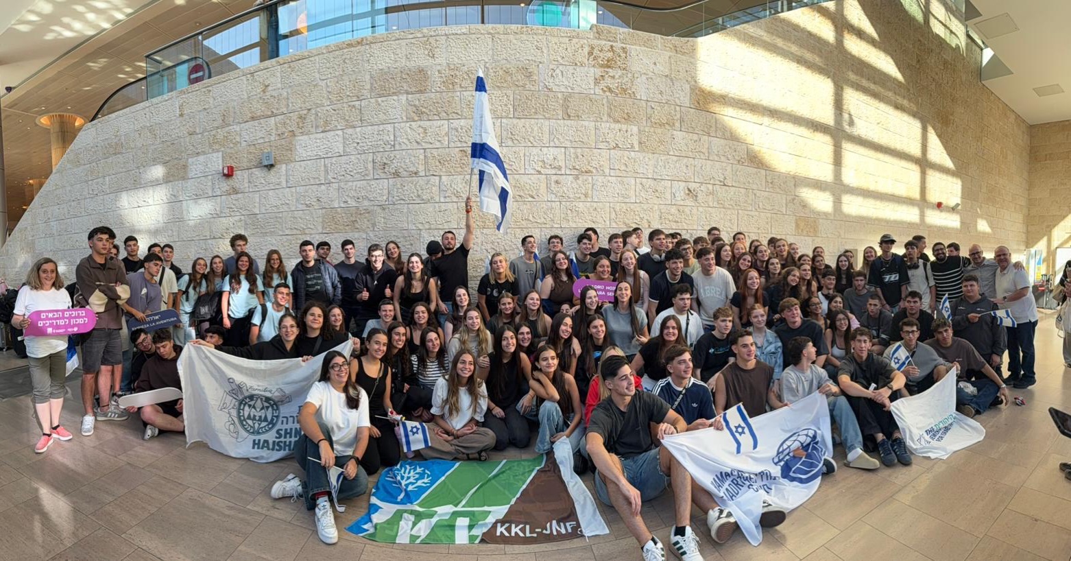 Nem a guerra interrompeu o percurso.
O Machon LeMadrichim Chutz LaAretz é um dos principais programas de formação de madrichim dos movimentos juvenis judaico-sionistas. Há décadas, prepara jovens da diáspora para assumir funções de liderança, educação e organização comunitária ao voltarem para seus países.
Neste ano, o início de mais um ciclo foi afetado pela guerra. A maior parte dos participantes não conseguiu chegar a Israel no momento previsto. Ainda assim, a resposta dos jovens foi direta. Insistiram em participar, mesmo diante das dificuldades, com disposição para aprender, se voluntariar e integrar a vida israelense em um período sensível.
Diante desse cenário, foi articulada uma solução fora do padrão. Em parceria com o Machon, o KKL viabilizou o fretamento de um voo para trazer mais de 100 participantes da América Latina, com conexão via Europa, até Israel.
O voo chegou.
A operação garantiu a continuidade de um programa que, ao longo de gerações, formou parte relevante das lideranças dos movimentos juvenis.
Formar madrichim segue sendo uma decisão estratégica.