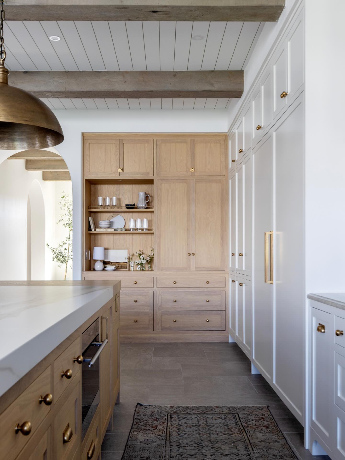Open vs closed storage…when we are designing a space we always handle this with clear intention and a sense of balance. You want enough open shelving to allow the opportunity to layer in some art and other pretty items but not so much that you are searching endlessly for things to fill it with or feel that it’s compromising what otherwise would have been valuable storage space. In this kitchen we created an open space to the left; a place to drop your keys and purse or house your shopping list or calendar. To the right we designed a closed storage unit that can be used as a coffee bar or small appliances cabinet. It’s a more practical space that we know won’t look picture perfect all the time. Close the doors and it’s out of site out of mind.