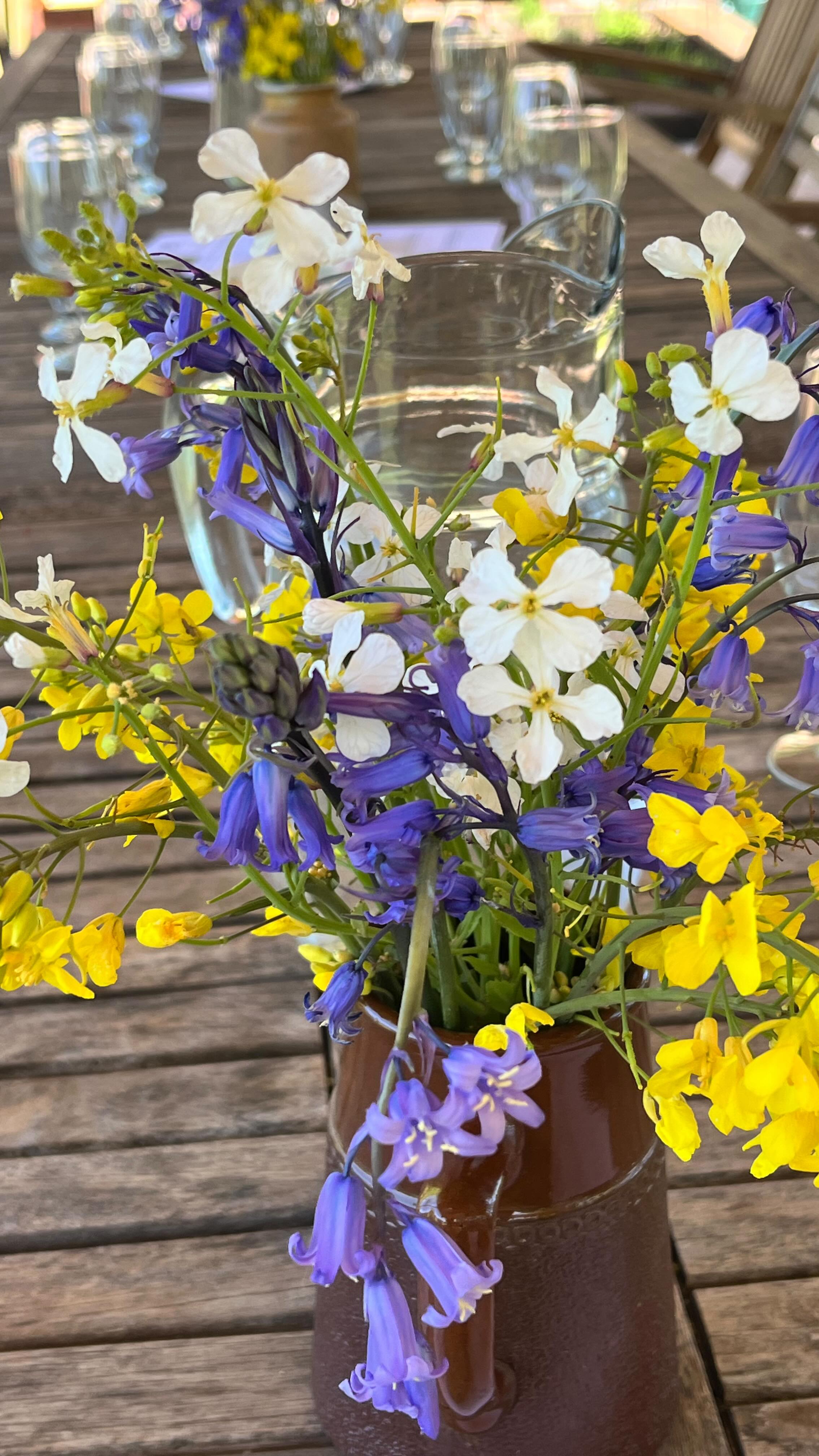 Bluebell time, in the ancient vineyard hedge and carpeting the little wood at the top. Paula picked a few for her wildflower table decorations for our first lovely hens of the year, and seen here relaxing in the Wine Barn at the end of a very busy day, barbecue smoking gently. You can see the new cabin that Ned and Paula built over the winter, to replace the old horse trailer we were using for storage.
