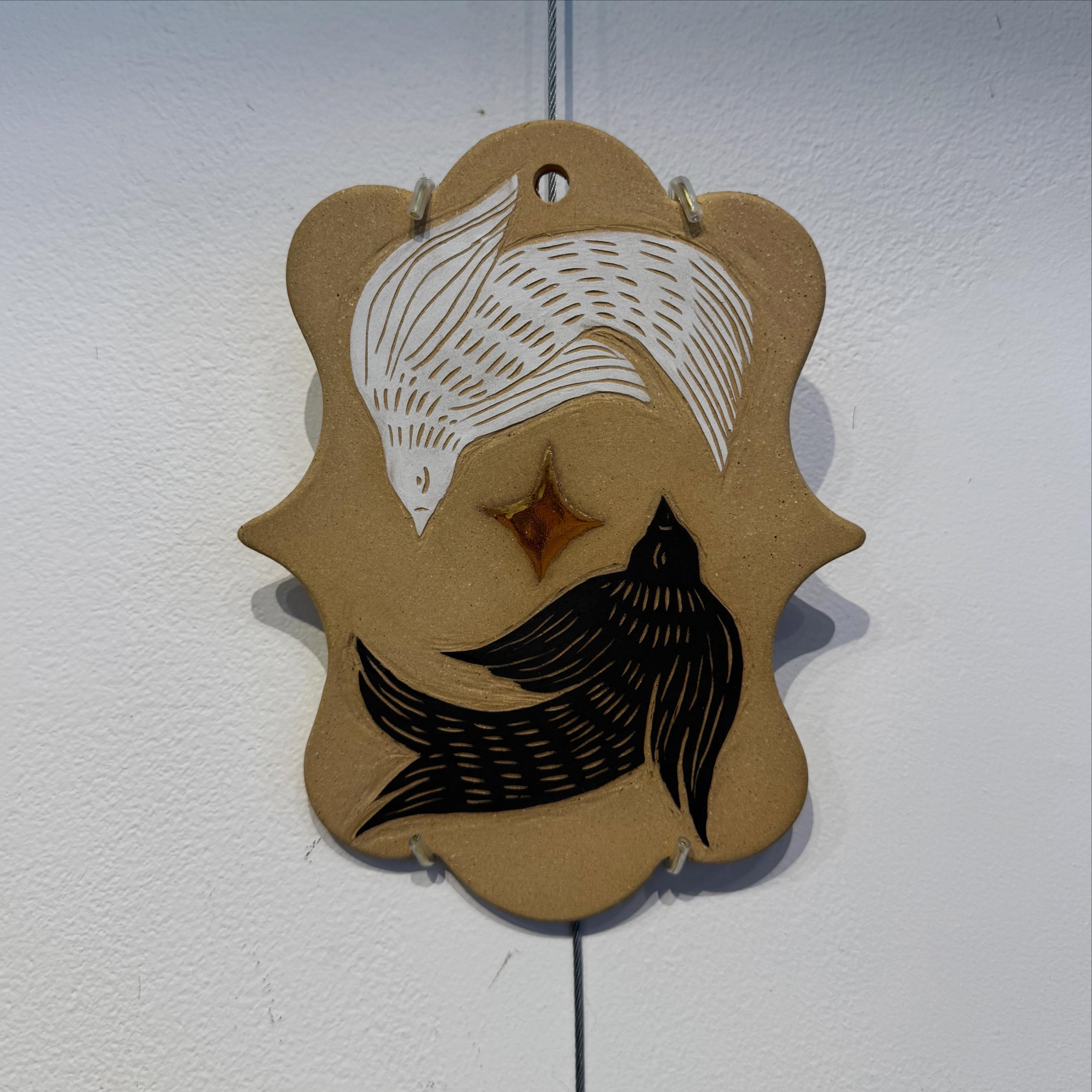 🚨ART ALERT🚨
Aimee Belanger
I am a Massachusetts native and teaching artist. After getting my BFA in painting from MassArt, I began experimenting with a variety of media, including printmaking, fibers, and eventually, clay. Over the past 10 years, I have combined my love of drawing and painting with my functional, wearable, and decorative stoneware work. Fire Sign Studio is my one-person ceramic business, and you can find my work at local shops and art markets throughout the Boston area.
This new body of work at Station 8 includes wall hangings and altars inspired by tabernacles, wall fonts, and folk illustration. The forms are reclaimed from the traditional Catholic ornaments I grew up with, and the imagery reflects my interest in mysticism, nature, and art history. I often leave my work unglazed to highlight the natural texture of the clay, and have added handmade fiber tassels, beads, and 22k gold luster. My altars and shelves are made to display your treasured objects, and I hope my work brings a little magic and nature into your space, whatever you pay devotion to.