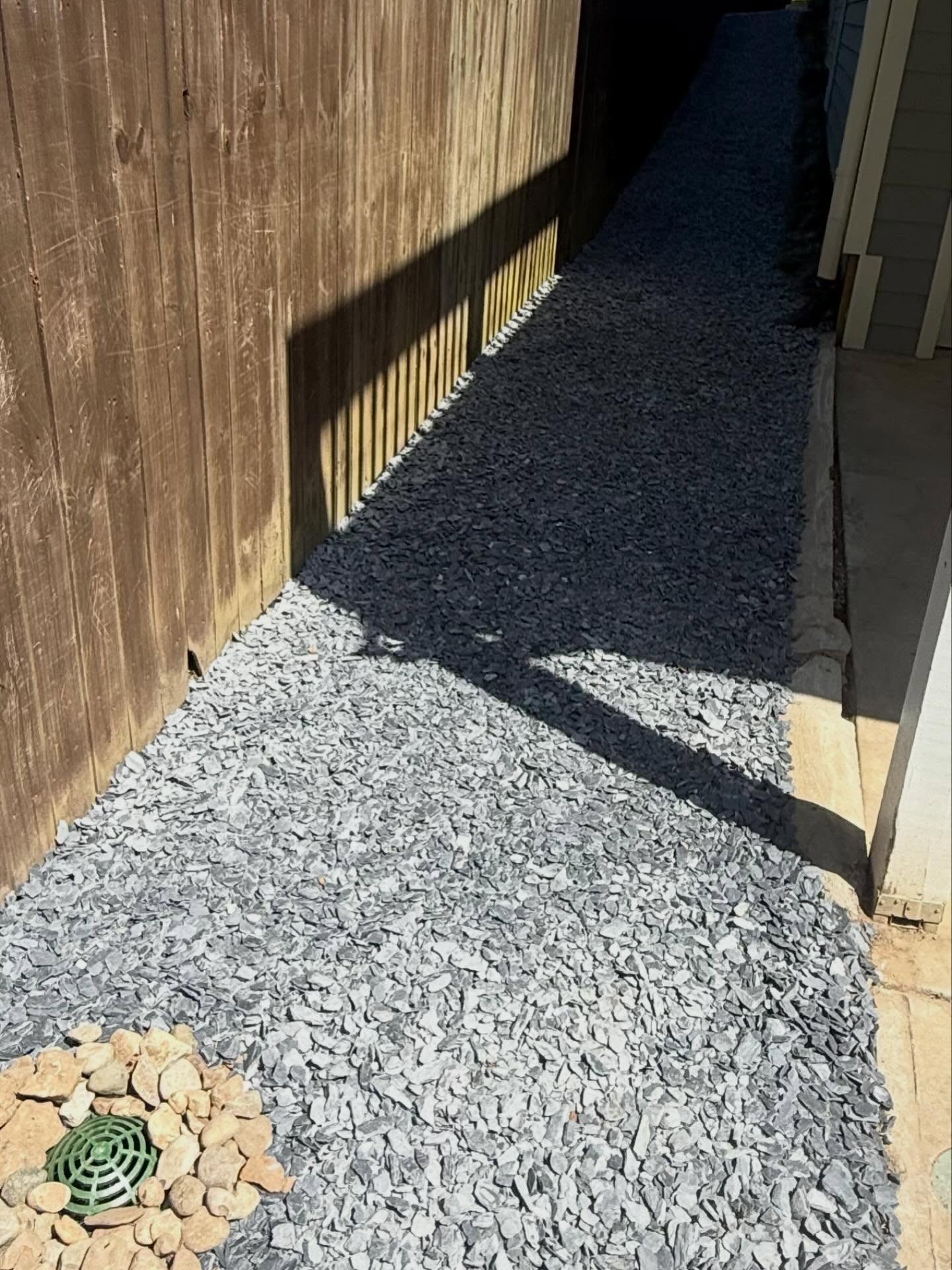 Check out this project install that we just finished up. We did a French Drain system here, three catch basins, fixed some of the existing buried downspout drains, removed grass and pea gravel to install these medium slate chips. Beautiful and functional.