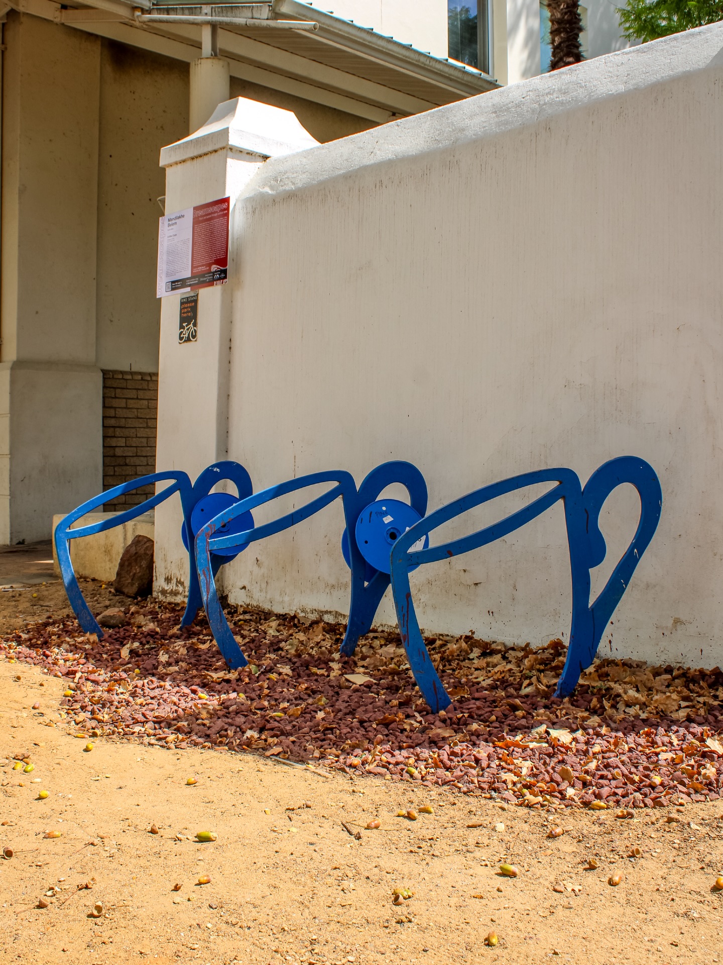 COFFEE CUPS by Mandilakhe Belem
2018 | Epoxy-coated steel | Ryneveld Street
This sculpture turns an everyday moment into something playful and shared. Shaped like a row of bright blue coffee cups, the bike stand celebrates two things Stellenbosch loves very much: good coffee and getting around on two wheels. In this town, mornings often begin at a café table and continue along tree-lined streets on a bicycle. The cups in this artwork are larger than life, as if a giant has just set them down for friends to gather around. But instead of holding coffee, they hold bicycles — inviting people to pause, park, chat, and connect. For children, the sculpture feels like stepping into a storybook where ordinary objects grow big and magical. For adults, it’s a gentle reminder that the simple rituals of daily life — meeting for coffee, cycling to work, sharing a conversation — are what give a place its character. By turning a practical bike rack into a cheerful public sculpture, Belem blends art with everyday function. The work suggests that creativity belongs not only in galleries, but in streets, sidewalks, and small daily habits. Like coffee and cycling, it brings people together — one cup, one bike, one moment at a time.
Learn more → sost.co.za/artwork/coffee-cups
Dreamscapes - Form and space through curious eyes curated by Dr Mike Mavura @mikemavura_ | 26 February 2026 – 30 January 2027
Presented by the Stellenbosch Outdoor Sculpture Trust, @visitstellenboschnow, and proud patron, Private Clients by Old Mutual.
#SOST #Dreamscapes #Stellenbosch #MandilakheBelem #WealthCurated