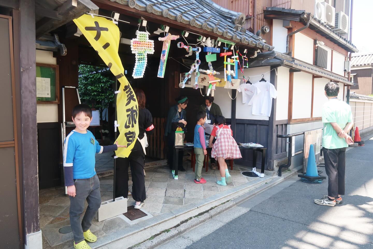 2026年5月5日 子どもの日
ナイス美術館2026が無事に終了しました。
晴天の裏寺極楽寺。
子どもスタッフ 12人(初参加5人)
ボランティアスタッフ 8人
ハレトケスタッフ 3人
が集まって、朝から準備をしました。
ポール台を円卓にしてお昼をみんなんで食べました。
今年のナイス美術館の約束。
子ども
・誰かに優しくすること
・疲れたら休むこと
・いっぱい食べること
大人
・しっかりしないこと
・自分を楽しませること
・いっぱい遊ぶこと
子どもたちには「大人がちゃんと一生懸命遊んでいるか見守っててください」とお願いしました。
準備が終わると、恒例の「ハッケヨーイ」「のこったー」の掛け声でイベントがスタートしました。
今年は4歳から高校生による、過去最多の作品が会場を彩りました。
発達や不登校相談ブースには、
中京区こども・若者の居場所ネットワークのメンバーが参加。
特定非営利活動法人Reframeの朝倉さん
@miho.asakura_kurara
発達凹凸っ子の保護者会ポレポレの粟さん
@porepore_kouryuu
京都子どものミライづくりポレポレ・いばしょかふぇの宅間さん
@kyoto.kodomonomirai.polepole
@ibasyocafe
京都市ユースサービス協会の米田所長
お子さんの気になりや子育ての相談を受け入れる場所づくりをしてくださいました。
「やっと話せる場所に出会えた」と涙する保護者さんもいらしたそうです。
ゲストは、
ポールダンサーのMECAVさん
@mecav_kotobuki
DJ nmxさんと子どもサウンドチーム
音響とミキサーに鵜飼ヨシキさん
@yoshikiukai
MECAVさんから演目内容の相談があったので「一番あがるやつ」とお伝えしたところ、かぐや姫の演目になりました。
DJタイムでは、こないだ立ったばかりの赤ちゃんや小学生とテクノで一緒に踊って汗がびっしょり。
2回目のショータイムは、極楽寺のご住職で京都市児童民生委員会長でもある鵜飼泉さん、デカルコ・マリィさん、俵まゆさんによる詩の朗読と舞踏、ピアノのパフォーマンス。
綺麗な日差しの中でたくさんの蝶々が飛んで、踊るおじいちゃんたち。蝶を追いかけて拾う子どもたち。
美しい景色の中で、HARETOKEの思いと俵さんの詩の内容と歌声が響いて、涙を流す人たちがたくさんいました。
今年は会場内の混雑による子どもへのプレッシャーを緩和するため、ショータイム時間の告知はしませんでした。ご覧いただけたラッキーなお客様たちが、歓声と拍手で会場をあたためてくださいました。
93人の来場の皆様。
13万円の募金が集まり、子どもスタッフ全員にお給料を渡すことができました。
帰り際にお見送りの時、
「みんなの思いがたくさん詰まっていて・・・」と、それから言葉に詰まって泣いていた人を笑いながら抱きしめました。
感情大爆発できる場所で、ここが必要な人がいるんだなって思えただけで、胸がいっぱいになりました。
みんなと一緒に過ごせて幸せな日でした。
来年も5月5日に、また会いましょう。
-------------------------
公式グッズ好評販売中!
子どもたちの作品をデザインしたグッズをご購入いただけます。収益の一部はこどもの居場所への寄付金として活用いたします。
Webショップサイト
https://suzuri.jp/HARETOKE
-------------------------
つくるの教室
💡自由創作クラス
✏️🎨デッサン・着彩クラス
〈火〜金〉9〜12時/14〜20時
〈土・日・祝〉 9〜12時/14〜17時
〈1日利用〉 9〜17時
👶新規幼児クラス
〈火〜金〉9〜12時/14〜17時
〈第1・第3 日曜〉 14〜17時
🍺闇ビール /子ども食堂・ 交流会
〈闇ビール〉毎月1回(定員20人)
☎️お問い合わせ
〈公式LINE〉https://lin.ee/fNAuSpg
#ナイス美術館
#中京区
#キッズアート
#中京区こども若者の居場所ネットワーク
#お絵描き工作教室
つくるの教室
闇ビール
ナイス美術館
発達凹凸
発達障害
HSP
こども食堂
闇ビール