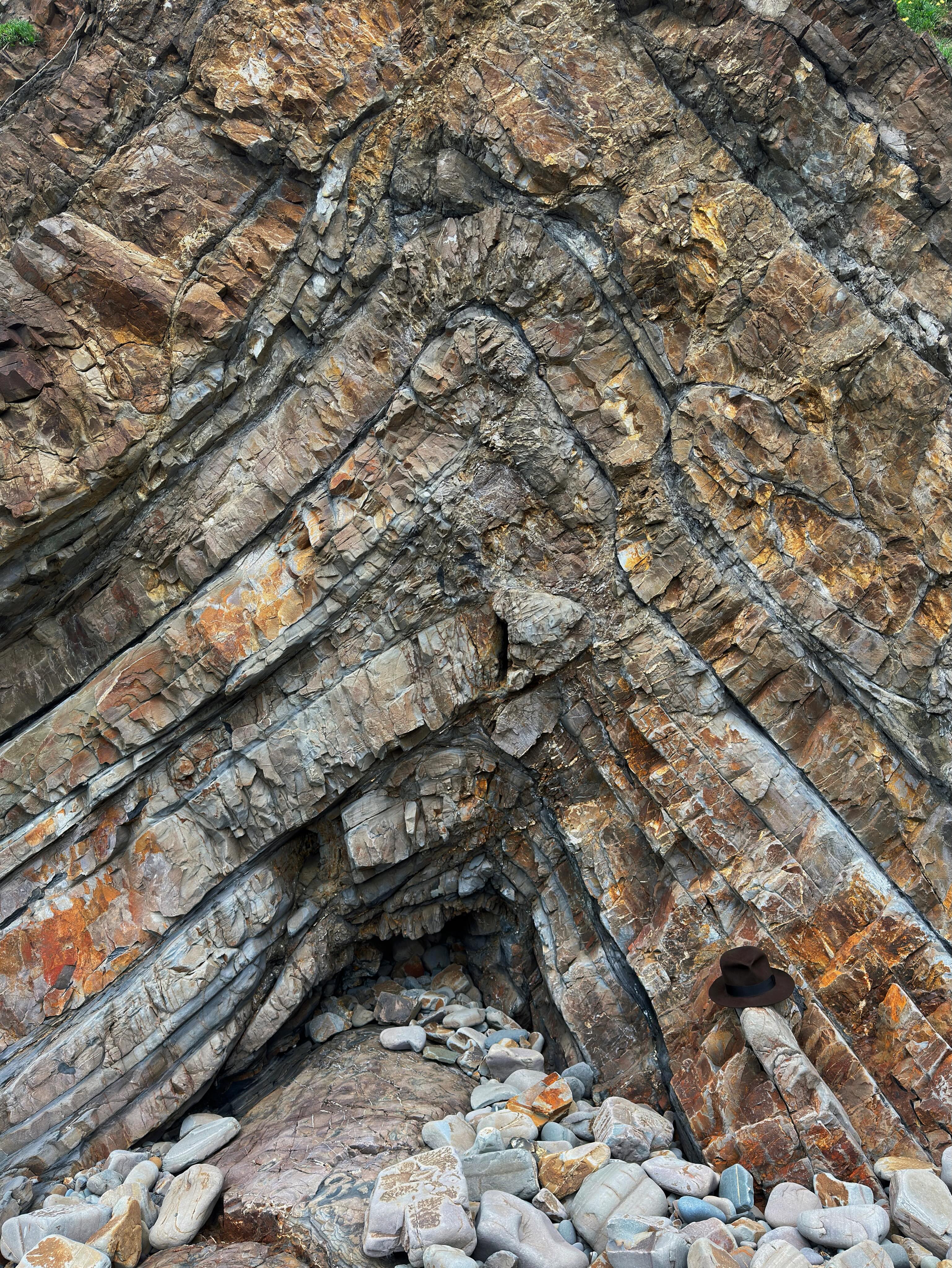 A beautiful upright anticline fold at Northcott Mouth at the top of Cornwall.
These layers of sedimentary rock were originally deposited as sediment gravity flows in the Culm Basin around 320 million years ago in the Carboniferous.
Squeezing and buckling of these rocks occurred during Variscan convergence. Cornwall was effectively squeezed together like an accordion in a mountain chain for over 80 million years!
Crustal shortening caused the sedimentary basins to concertina together. Their stratified sedimentary contents got squished and expelled out on to neighbouring basins, in doing so forming these beautiful structures.
This fold is upright. In other words, if you join all the hinge points the line it creates (the fold axial trace) is vertical.
We use the term hinge for where the two fold limbs meet; where the bedding surface has buckled if you like. Think of it like the hinge of a door or the spine of a book.
For folds to form these rocks must have undergone some sort of shear, a type of deformation experienced by a rock mass. There are two types of shear - pure and simple (anyone singing the Hear’Say song now?).
I’ll use the “cloth on a table” analogy to explain.
If you pushed a cloth together equally from both sides it would cause it to buckle as a series of upright folds like here. This is pure shear.
If you move your hand along the top of the cloth it would cause it to “ruck” over. These rucks tilt in the direction of the top sense of shear, the direction you move your hand in. This is simple shear.
Many folds in Cornwall have a top sense of sheer to the north - Variscan convergence had a northward direction.
The difference here in north Cornwall is controlled by the symmetrical, full-graben geometry the Culm Basin in which these sedimentary rocks were originally deposited.
Whilst folds on the northern side of the basin face north, at the southern margin its contents spilled out southwards during inversion. In the middle of the basin like at Northcott Mouth the folds are upright, more akin to pure shear.
A tectonic story well worth seeing!
Hat for scale.
#structuralgeology #tectonics #geology #geologist #cornwall