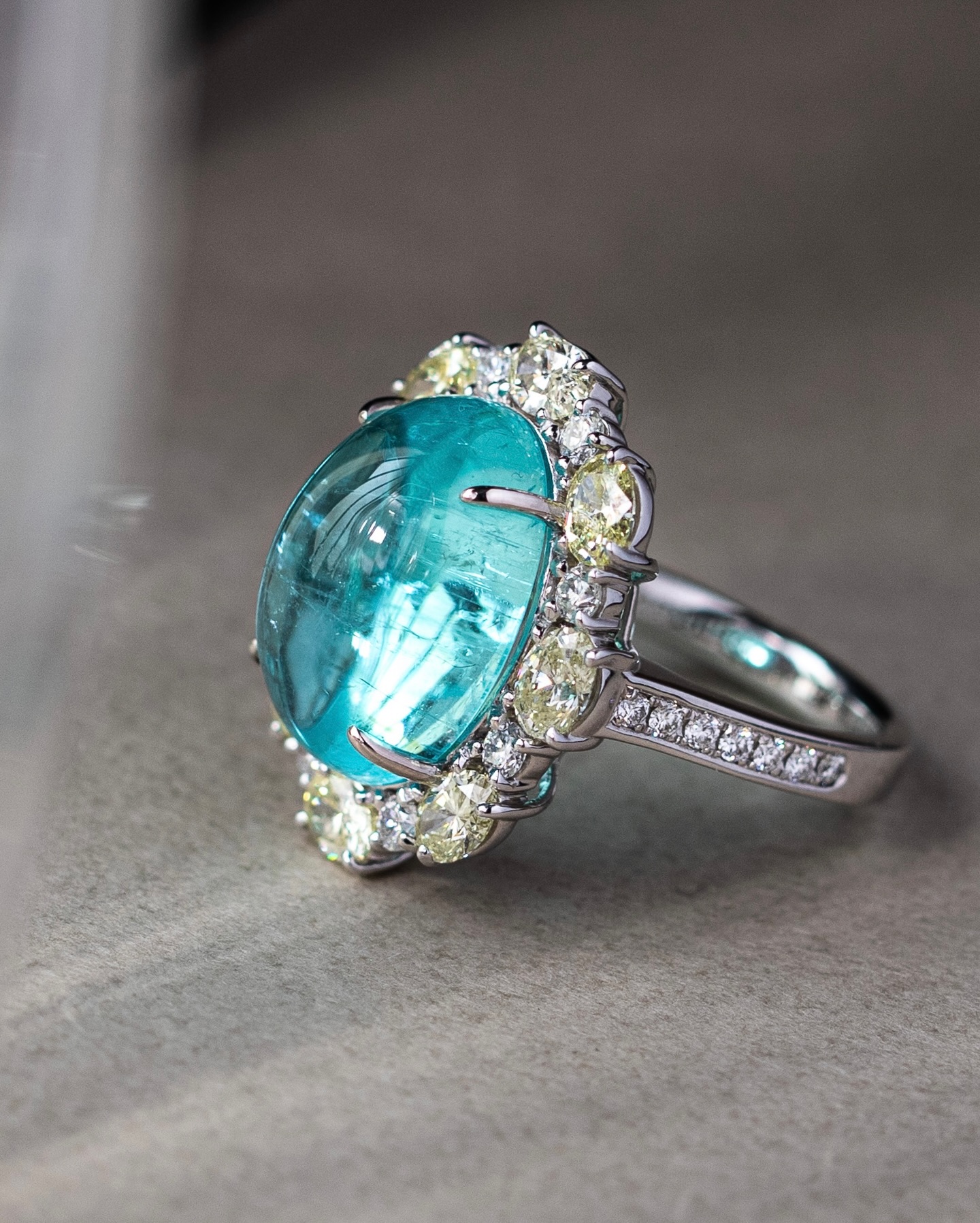 A glow so vivid, it almost feels unreal.
Featuring a rare 12-carat cabochon Paraiba Tourmaline, this one-of-a-kind piece captures the mesmerising neon-blue glow that has made Paraiba one of the world’s most sought-after gemstones. Cut in a smooth cabochon form rather than the usual faceted style, the gemstone reveals a softer, almost liquid-like luminosity — allowing its colour to take centre stage.
Discovered for this year’s The Annual Gem Affair — Colours & Cuts, this extraordinary stone celebrates the beauty of colour in its purest form, and how different cuts can completely transform the expression of a gemstone.
Discover this exceptional Paraiba Tourmaline at our Ann Siang Hill Boutique from 20–24 May 2026.