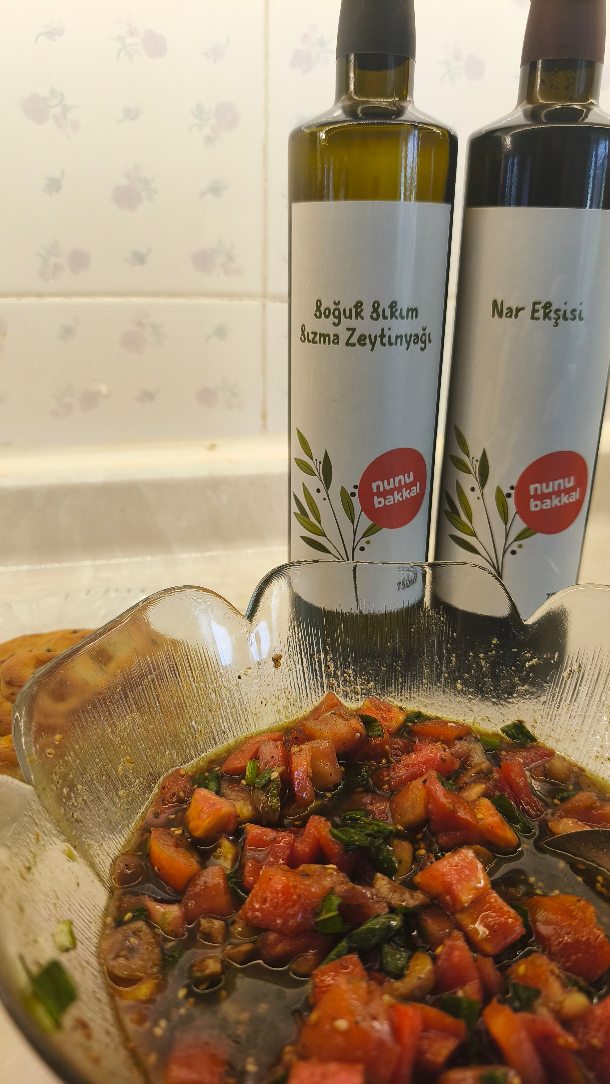 Mutfaktan nefis kokular yükseliyor! 🥣✨ Bugün bakkal defterinin ilk tarifini yapıyoruz.
Siz yorulmayın diye en çok denemenizi istediklerimizi bir araya getirdiğimiz tanışma kolimizin yıldızları bu pazar tezgahta yerini aldı. Sıcacık bir fırın külçesinin yanına en çok yakışan, tamamen bitkisel ve dürüst malzemelerle hazırladığımız Vegan Zahter Salatası tarifimiz yayında! 🌿🍅
Malzemelerimiz:
nunu kahvaltılık zahter
nunu sızma zeytinyağı
nunu nar ekşisi
İki adet domates
Taze soğan
Bahçeden taptaze toplanmış nane
İnce doğranmış yeşil zeytin ve bir tutam tuz
Aromaların zeytinyağıyla buluşup uyandığı, bahçenin tazeliğiyle birleştiği o anın ritmi bizim için sadece bir tarif değil; sömürüsüz ve temiz gıdanın mutfağımızdaki neşesi. 🤍
Üstelik bu tarifte kullandığımız nunu ürünleriyle Umut Fonu’muzu büyütmeye devam ediyoruz. Her alışverişinizin %3'ü; sokakta yaşayan ve kurtarılmış hayvanların tedavi süreçlerine, bölgedeki doğa koruma çalışmalarına, insana ve dayanışmaya doğrudan destek oluyor.
Videonun sesini açmayı ve ekmeği ekrana banmayı unutmayın! Detaylı tarif adımları videoda, temiz ve adil malzemeler ise web sitemizde sizi bekliyor. Afiyet olsun! 🥖