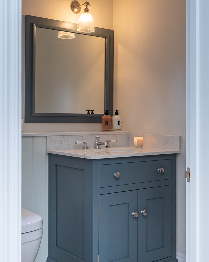 You don't need a large space to make an impact. The muted blue vanity adds depth, while the marble top and warm lighting bring softness and balance. A simple combination that feels timeless for years to come. #BespokeDesign #KitchenInspo #InteriorDesign #ModernLiving