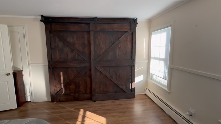 Dave and Anne Marie from Newburyport, MA wanted bypass rustic barn doors to match the decor in their home that would cover the bedroom closet.
The Barndoorist used Civil War-Era pine and dark wax to craft and install these with a smooth ply painted back inside (best so lint does not catch on the wood).
Bypass door systems are robust and live out into the space, but we create closure around the sides and ends with our side board feature. This system required the top beam because the olde home had horse-hair plastered walls and finding purchase into the wood was the key!
Later, they asked The Barndoorist to come back and add the extensions to the beam up top so it goes wall to wall, and it now looks like it’s been there for all time!
#Newburyport #rustic #barndoors #slidingdoors #customdoors
