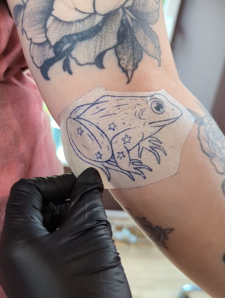 lil frog friend gap filler for Jade 🐸✨
I placed the stencil and drew on the leaves with a Sharpie (I forgot to take another photo)
Jade chose the frog from my recent flash, but the position wasn't going to work well with the gap, so I redrew a unique froggy for her! I love using the little stars to make it more ✨whimsical✨🌿
We had a lovely chat and I really appreciate talking to you about markets!
Jade creates super cute glass cloches, with eco friendly 3d printed frogs that she hand paints, to make beautiful, whimsical dioramas. @idioticjelly_makes
Check them out 🥹🐸🌿✨
Looking forward to seeing how this healed! I do a lot of my shading in grey wash, so it will heal a bit lighter
I have limited space left in July, booking up until end of October right now ✨
To make an enquiry fill in the enquiry form in my bio or email me at booking@ericattattoo.com 💖
I will be at the Midnight Solar Market on 27th July, selling my crafts and prints ✨
Also on 17th/18th September I will be guesting at Wild Wood Tattoo Studio in Newcastle (17th is fully booked)
Owned by @uprooted_ink
Excited!😻
#edinburghtattoo #frogtattoo #edinburghtattooartist #whimsicaltattoo #glasgowtattoo
