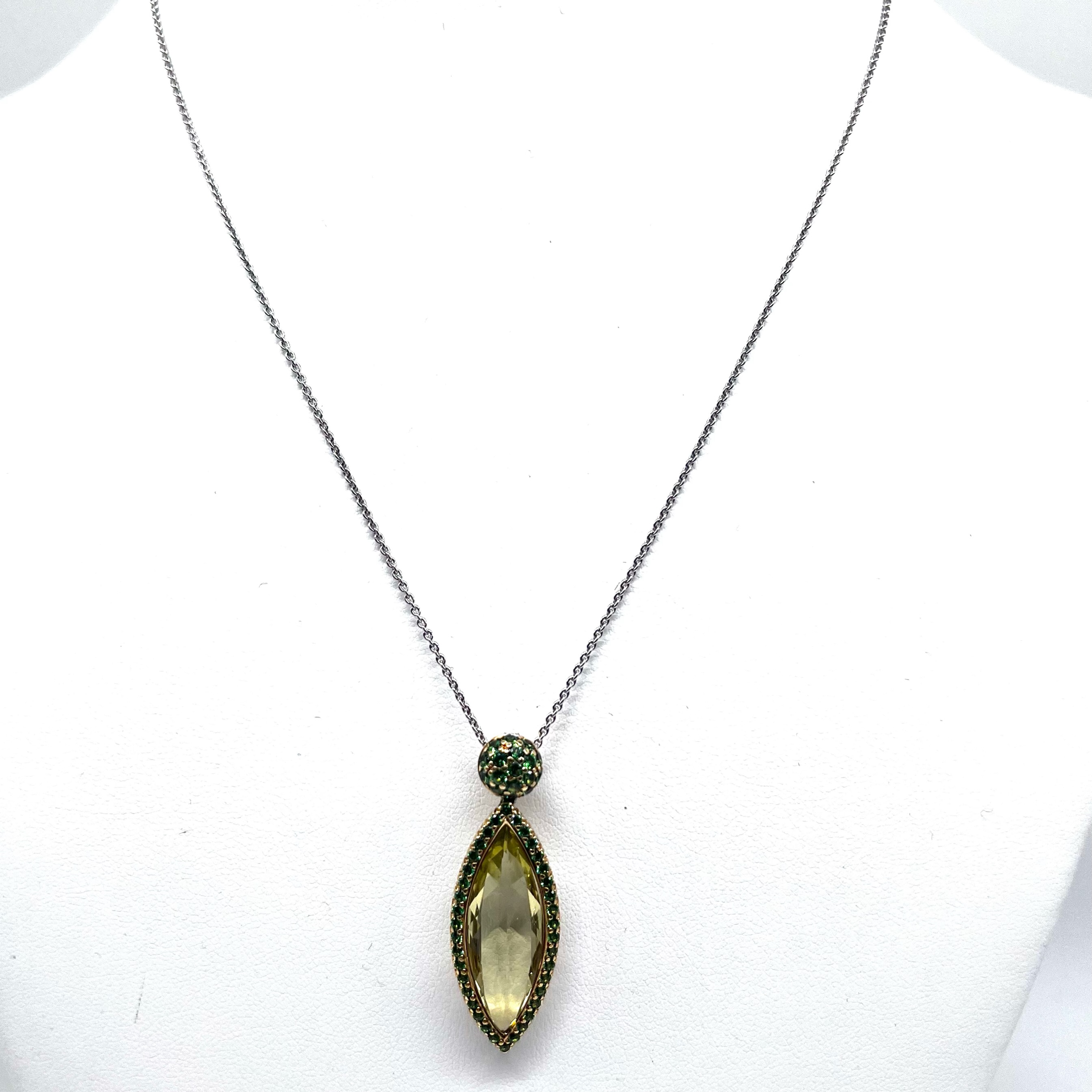 18K Gold Lemon Quartz & Tsavorite Garnet Pendant Necklace
Elegant 18-karat gold pendant featuring a beautifully faceted navette-cut lemon quartz in a polished yellow gold bezel setting. The luminous lemon quartz is framed by a halo of pavé-set tsavorite garnets, with additional pavé tsavorites adorning the domed bail for a striking contrast of fresh green and golden hues.
The pendant is suspended from a fine 18-karat white gold cable-link chain, creating a sophisticated two-tone design that is both contemporary and timeless.
A beautifully crafted statement piece with exceptional attention to detail, perfect for both everyday elegance and special occasions.
Details:
* 18K yellow and white gold
* Navette-cut lemon quartz
* Pavé-set green tsavorite garnets
* Two-tone gold design
* Fine 18K white gold chain
* Excellent condition