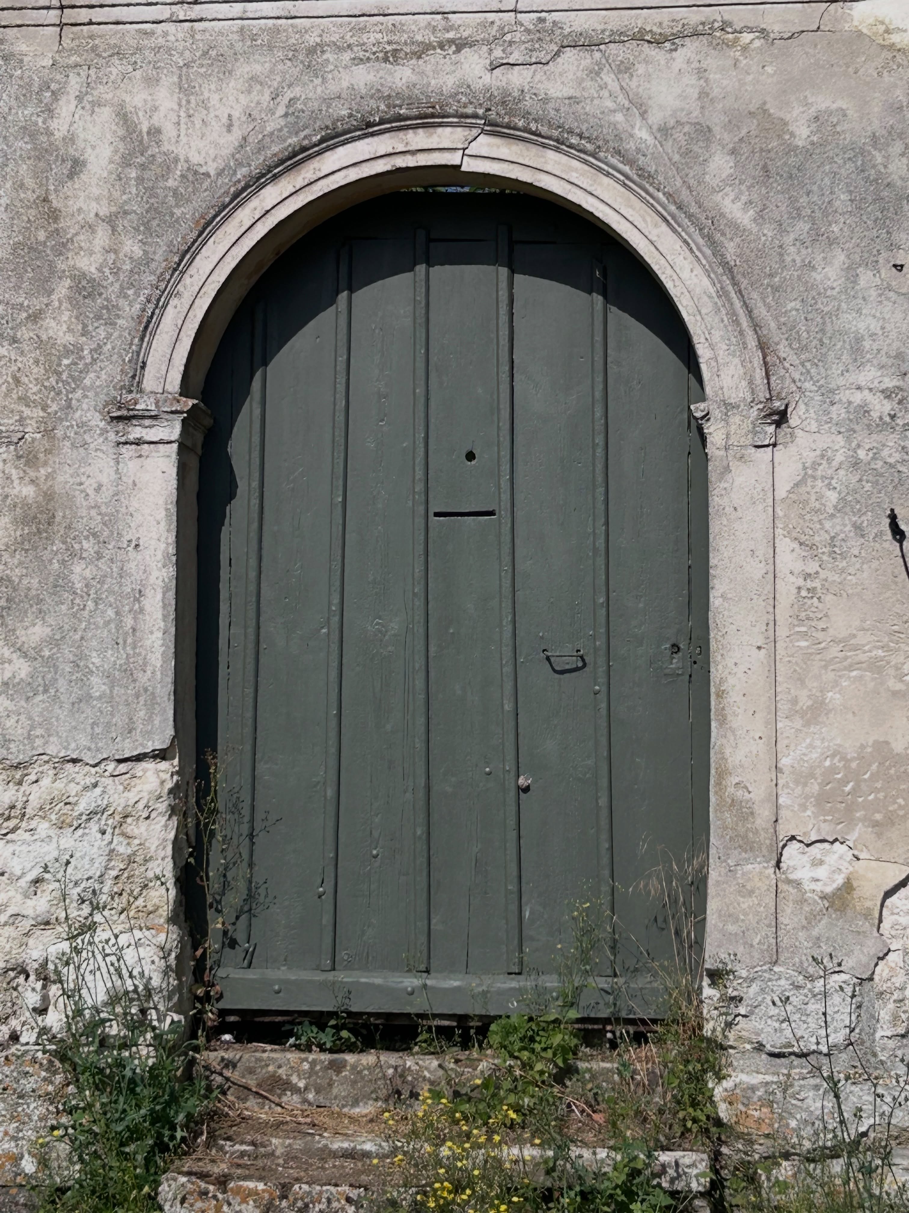 Je crois que j’ai toujours aimé les portes.
À Paris, je pouvais ralentir juste pour admirer une vieille porte cochère. Ici, dans mon village, c’est exactement pareil.
Je me surprends à imaginer les mains qui ont tourné ces poignées pendant des décennies, les enfants qui les ont claquées en courant, les voisins qui s’y sont arrêtés pour discuter, les allées et venues d’une vie entière.
Une vieille porte n’est jamais seulement une porte.
C’est le premier chapitre d’une maison.
Alors oui… j’avoue avoir toujours un petit pincement au cœur lorsque je vois une demeure ancienne perdre sa porte d’origine au profit d’un portail flambant neuf en PVC ou en aluminium.
Ce n’est pas une question de goût, ni de modernité.
C’est simplement qu’on remplace souvent un morceau d’histoire par quelque chose qui, lui, n’a encore rien à raconter.
J’aime les portes qui grincent un peu.
Les ferronneries usées par les années.
Les bois patinés par le soleil et la pluie.
Les imperfections qui témoignent du temps.
Parce qu’elles nous rappellent que la beauté n’est pas toujours dans le neuf.
Elle est souvent dans ce qui a traversé le temps.
❤️ Et vous… vous les remarquez aussi, ces vieilles portes, ou je suis la seule à lever les yeux pour elles ?
Une porte ancienne ne ferme pas seulement une maison. Elle garde la mémoire de ceux qui l’ont habitée.