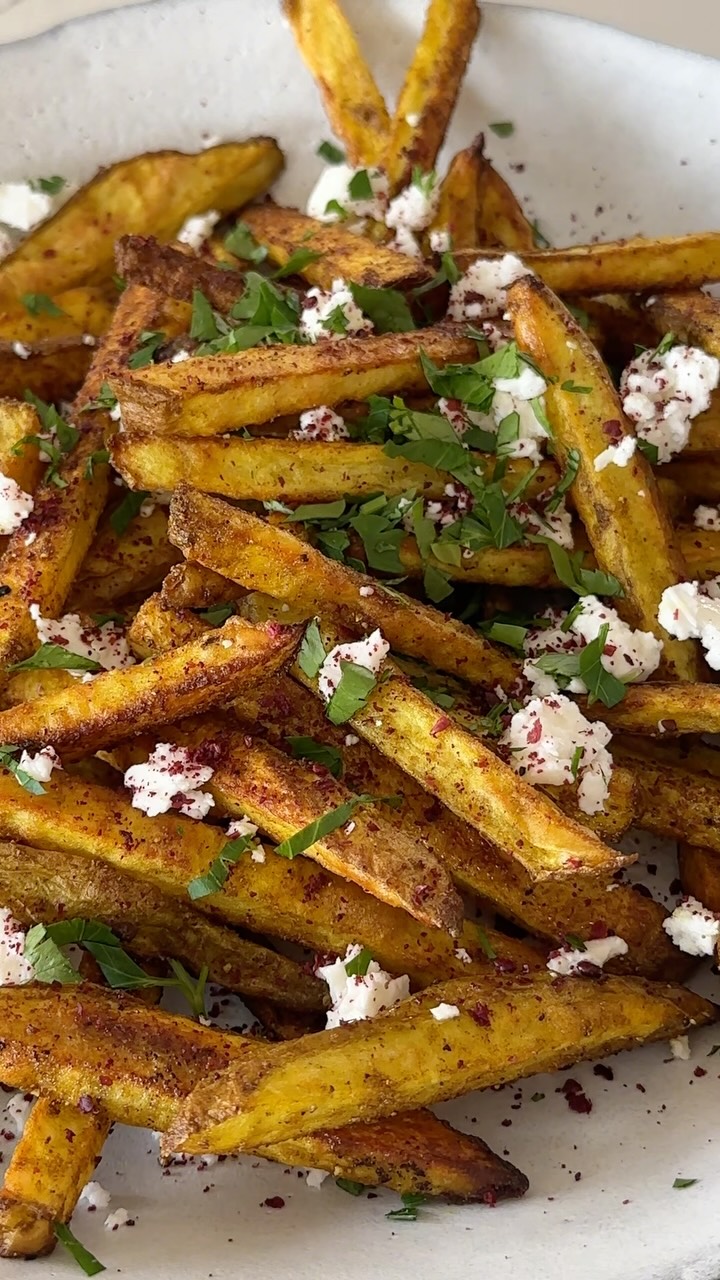 SHWARMA SPICED FRIES W/ FETA
All I can say is: Where have these fries been all my life??? The shawarma spice, the crispy-creamy experience only a French fry can deliver (in this case baked in the oven!), the crumble of feta at the end…I declare these absolute perfection. And check out who made a cameo for a taste! @shaharcohen90 👀
2 ¼ tsp ground cumin*
½ tsp ground turmeric*
½ tsp ground cinnamon*
½ tsp kosher salt, plus more for seasoning
⅛ tsp freshly ground black pepper
2 large Russet or Idaho potatoes (1¾ lbs.)
3 TB olive oil
½ cup crumbled feta
½ cup chopped parsley
Sumac, for garnish
Preheat the oven to 450°F.
Combine cumin, turmeric, cinnamon, salt & pepper in a small bowl to make the spice blend.
Cut the potatoes into ¼-inch thick planks; cut lengthwise into fries. Cover with ice water in a large bowl for 5 min. Drain; arrange on a dry kitchen towel and pat dry completely. Arrange in a single layer on a large parchment lined rimmed baking sheet. Drizzle with olive oil, sprinkle spice blend; toss to coat evenly. Roast, not moving until the potatoes are browned and crisp around the edges, around 25-30 min.
Transfer to a serving plate with feta & parsley. Sprinkle with sumac and salt to taste.
*The cumin, turmeric & cinnamon can be replaced with 2 tsp total shawarma spice blend