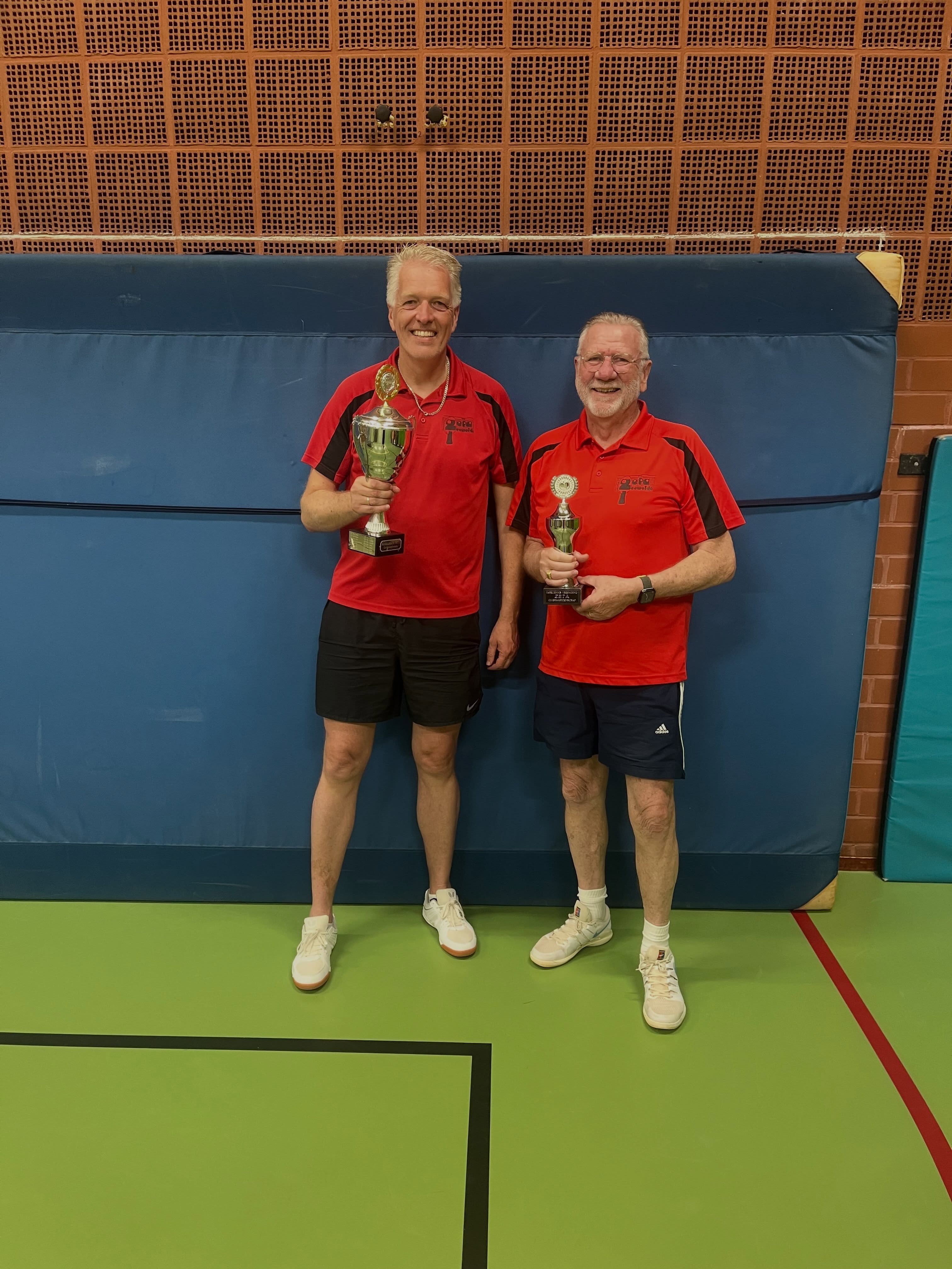 🏓 De jaarlijkse clubkampioenschappen van TTV ZETA zitten er weer op en het was opnieuw een sportieve en gezellige avond vol mooie wedstrijden!
Bij de junioren wist Mart van Es zijn titel met succes te verdedigen door in een spannende finale te winnen van Roan Gieling. Bij de senioren lag de titel voor het eerst in jaren voor het grijpen, nadat viervoudig clubkampioen Daan Bakker niet meer deelnam. Uiteindelijk was het Harry Sijm die na een indrukwekkende reeks wedstrijden de beker in ontvangst mocht nemen en zich clubkampioen van 2026 mag noemen. De winst in de B-ronde ging naar Wout Jansen.
Van harte gefeliciteerd aan alle prijswinnaars en bedankt aan alle deelnemers en de organisatie voor een geweldige avond. Op naar de volgende editie! 🏆👏