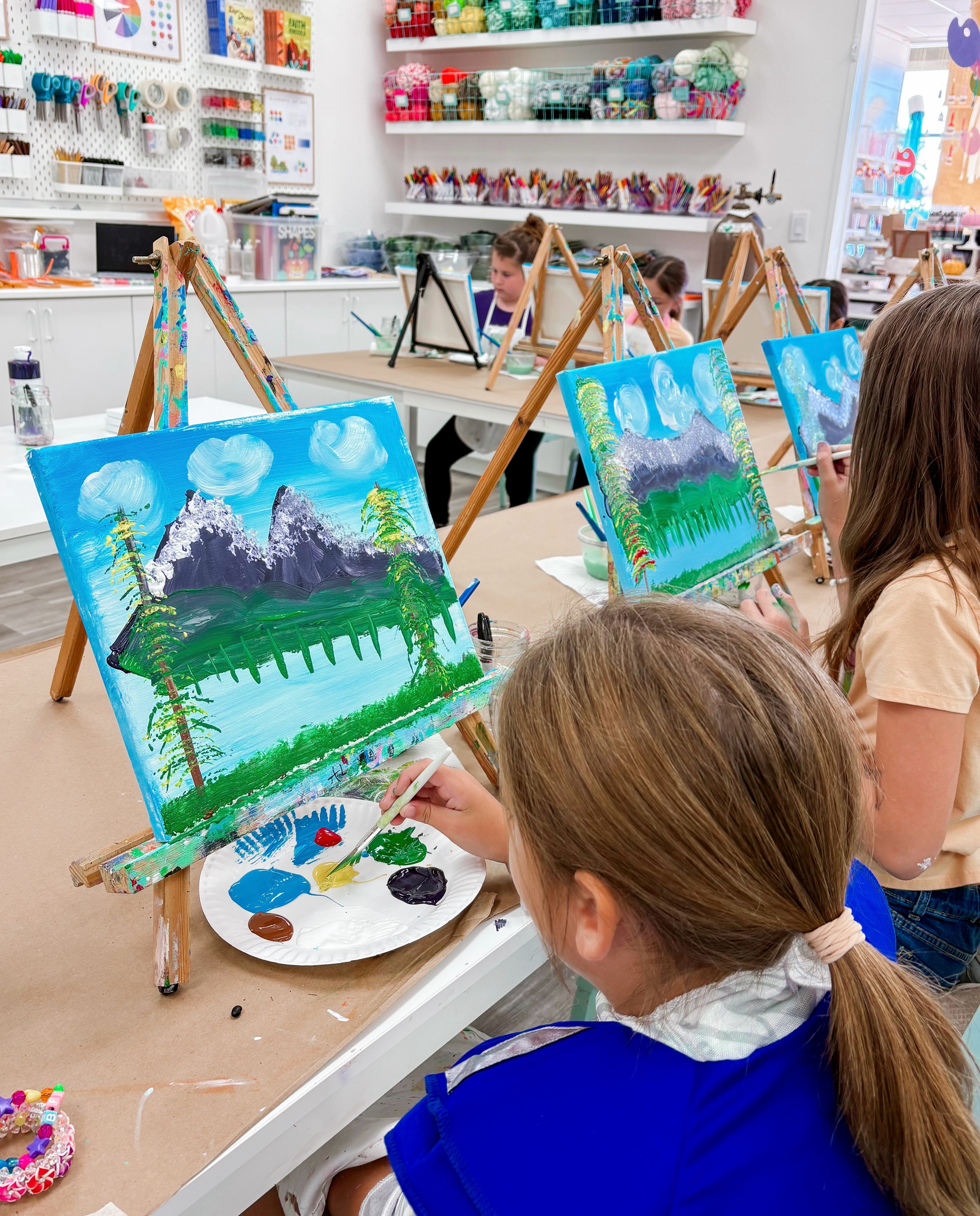 Last school year, our second through fifth grade Homeschool Makers stepped into the joyful world of Bob Ross! Together, we explored his life and artistic journey, read stories about how he became one of the world’s most beloved painters, discovered the magic of his iconic television show, and practiced many of his signature painting techniques. Before long, Bob’s famous words - “happy little accidents” - became our classroom mantra, reminding us that mistakes are simply opportunities to create something beautiful.
To make the experience even more memorable, Bob Ross himself made a special guest appearance during our canvas painting lesson! His surprise visit filled the studio with laughter, excitement, and plenty of happy little trees, creating a memory our young artists hopefully will never forget!