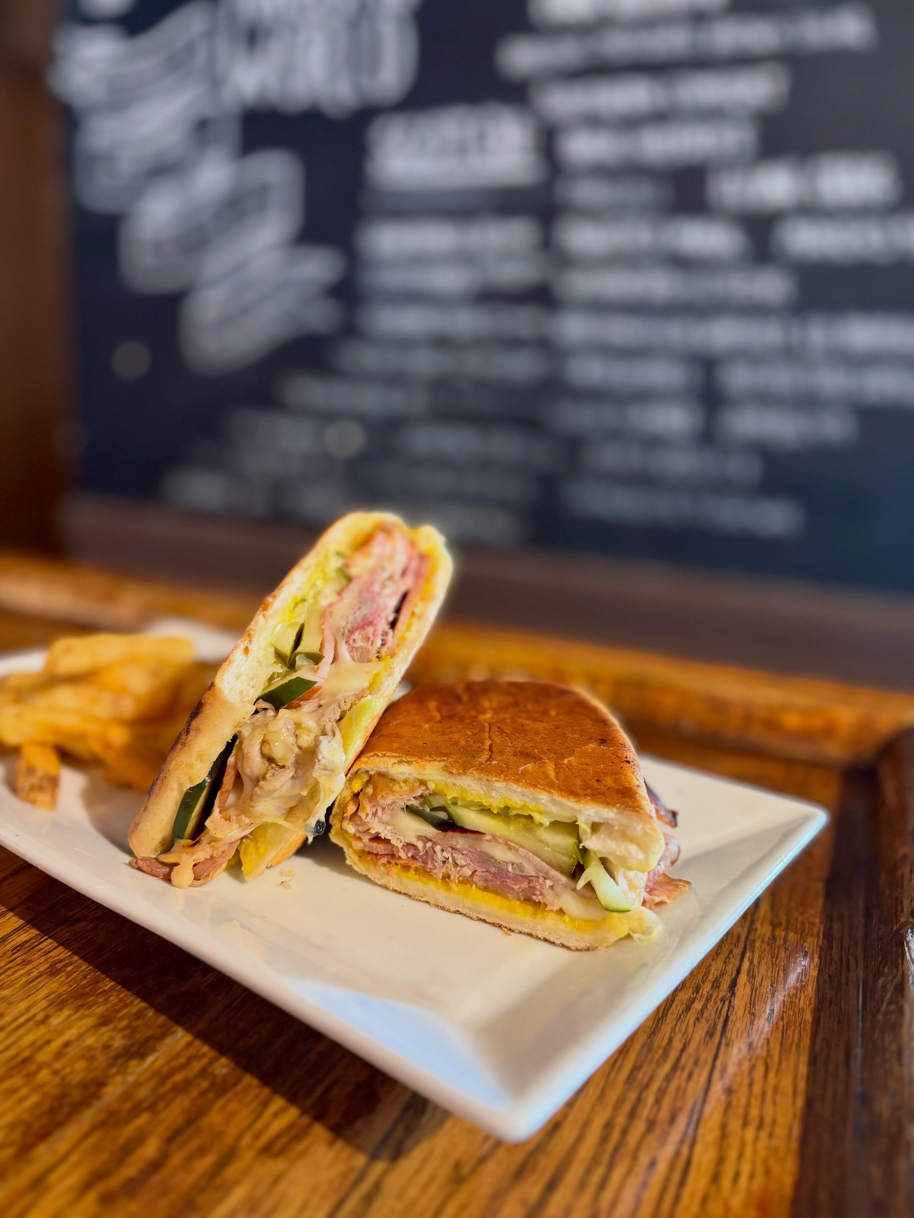 We’re bringing a little Cuban-inspired flavor to the table this week. Come hungry.
-
Weekly Specials: July 13 - July 18, 2026
-
Lunch Special: Cubano
Marinated shredded pork, sliced ham, Swiss, house-made pickles and yellow mustard pressed in a crispy hoagie
-
Specialty Burger: Cuban Frita burger
Grilled beef patty piled high with crisp shoestring fries, lettuce and red onion, slathered in smokey-spicy ketchup on a toasted bun
-
Daily Soup: Cuban black bean topped with diced avocado *vegan
-
Birch Salmon: Chili-lime seasoned grilled salmon topped with fresh cucumber pico