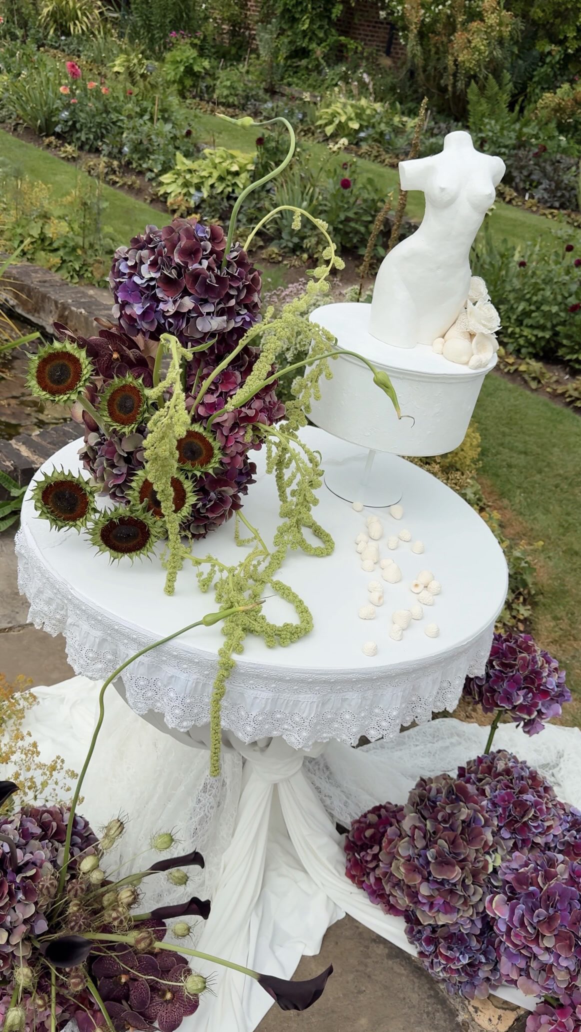 A moment for the wedding cake table of 2026… 🍇
She was pure feminine art. A sculptural torso made of cake framed by deep burgundy blooms, cascading amaranthus and flowing drapery, creating a focal point that felt as much like an installation as it did a cake display.
One of my favourite designs I’ve created this wedding season with the talented Justine from @itsnotjustcake 🤍
Shoot Host & Florist @burtonsblooms
Shoot by @portfolioinbloom
Cake @itsnotjustcake
Venue @cheniesmanorweddingsandevents
Photographers @luciewatsonphotography and @weddings.by.miriam.c.wahl
Content Creator @weddingluxesocials
Stylist & OTD Coordination @weddings_akilahandco
Tableware @harrietstable
Furniture @optionsgreathire
Candles @theglasshouselondon
Stationary @threadandvow_
Draping @loving.events