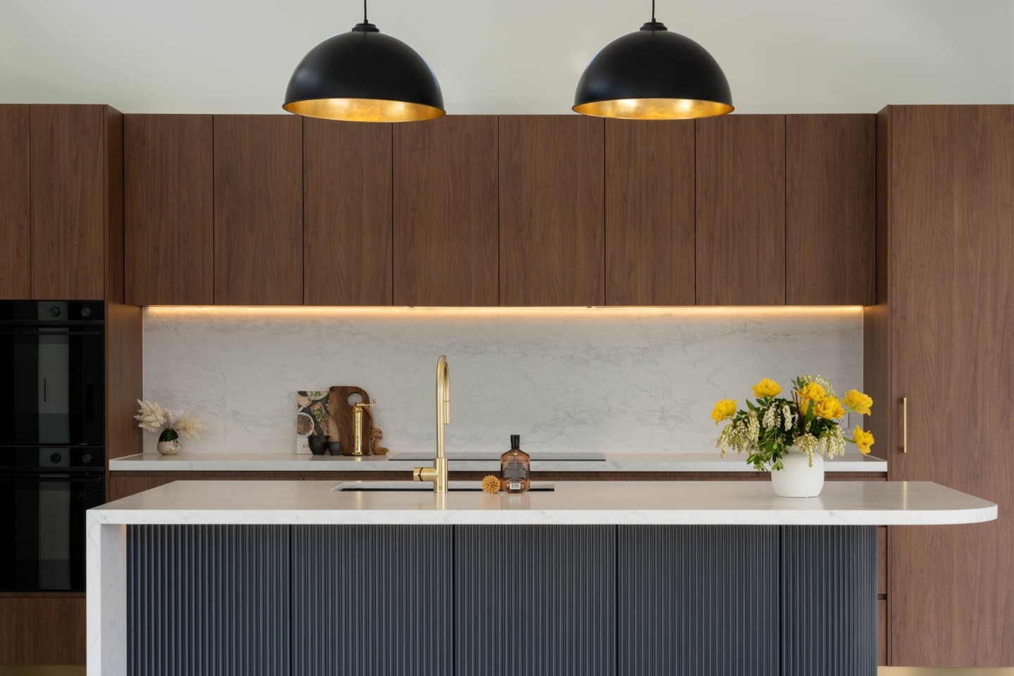 I don't know about you, but when I look at this kitchen it just feels like a warm hug. The rich chocolate tones of Polytec's Florentine walnut joinery, paired with the classic dark blue and brass accents create a balance of modernity and cosiness that's offset by the more industrial feeling of the polished concrete floors. It's elegant, it's sophisticated and we're here for it.
📸 @benandgab