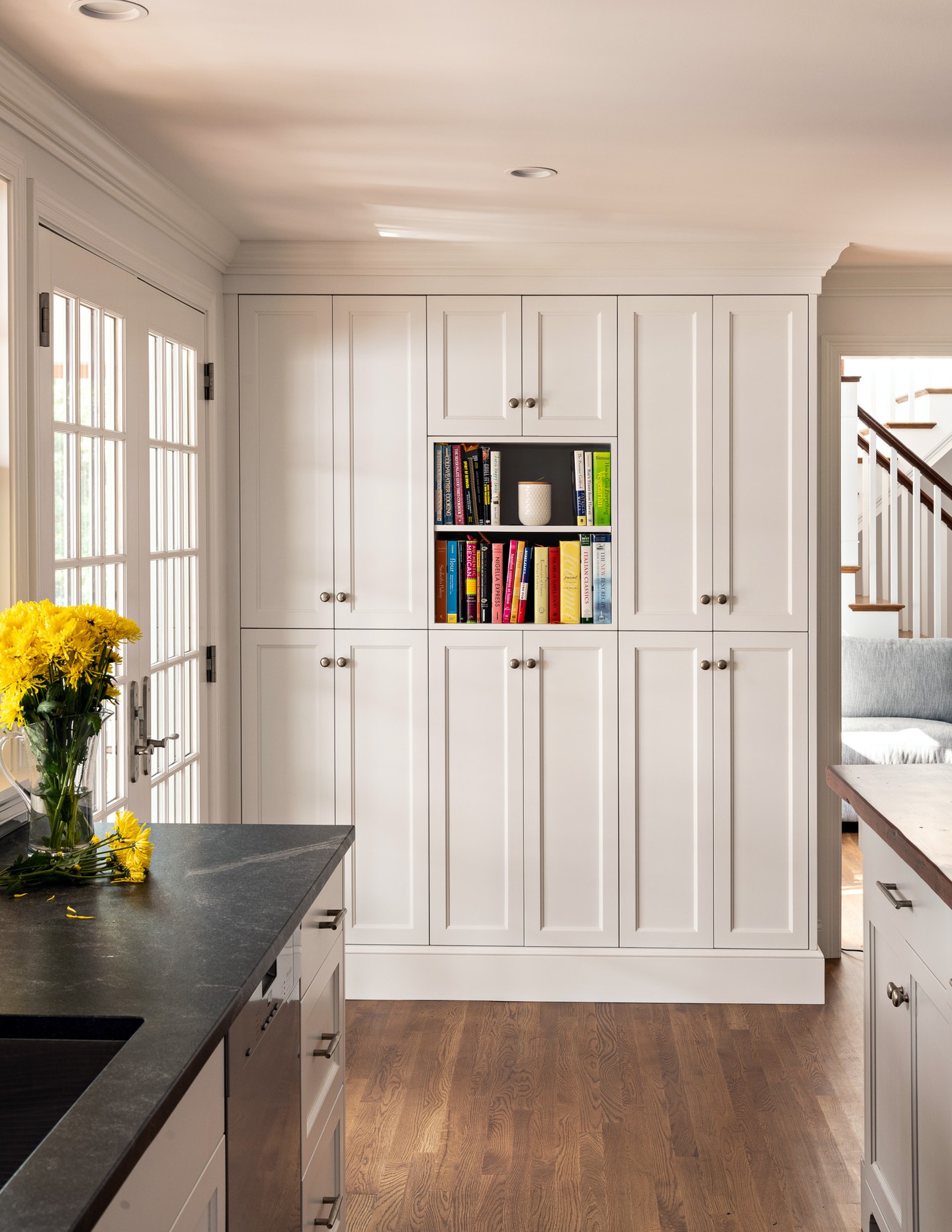 In a thoughtfully designed renovation, custom millwork does more than add storage—it brings character, continuity, and purpose to the entire home.
In this Orleans residence, full-height kitchen cabinetry maximizes storage while maintaining clean, balanced proportions. The custom island adds warmth and craftsmanship with its wood countertop, paneled base, and finely detailed columns.
Beyond the kitchen, built-in cabinetry and open shelving turn otherwise unused wall space into functional architectural features. Surrounding the fireplace, the millwork was carefully integrated with the mantel and existing trim to create a seamless backdrop for books, artwork, and personal collections.
From consistent door reveals and thoughtfully scaled moldings to the balance of concealed storage and open display, every detail contributes to a home that feels refined, functional, and distinctly its own.
Architect: @frankshirleyarchitects
Photography: @dancutronaphoto
#CapeAssociates #CustomMillwork #CustomCabinetry #ArchitecturalMillwork #KitchenDesign #BuiltInCabinetry #CapeCodHomes #HomeRenovation #Craftsmanship