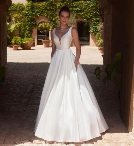 Idalia is an exquisite princess bridal gown with a stunning cathedral train crafted from high quality Mikado fabric. The romantic gown showcases an elegant V-back along with a sophisticated V-neckline and a natural waistline including a 1.6 inches seam allowance. This sleeveless dress offers the convenience of pockets and elegant pleats on the skirt combining practicality with timeless style.
@biancoevento - Style ‘Idalia’
#simplewedding #plainweddingdress #elegant #timelesswedding #yateley