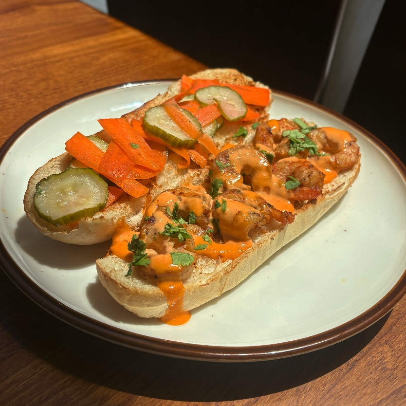 Our August special is here: Shrimp Banh Mi.
Toasted bread, pickled cucumbers and carrots, marinated sautéed shrimp, sriracha aioli, and fresh cilantro. Paired with our carrot ginger soup for the full experience.
Come try it this month!