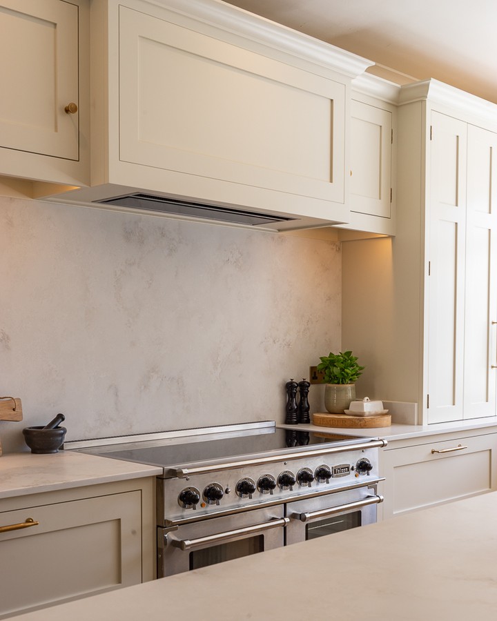 A focal point does not always need an elaborate surround. Sometimes, letting the range sit against a clean stone backdrop creates far more impact. With ventilation integrated discreetly above, the entire elevation feels lighter, quieter and more intentional. #BespokeDesign #KitchenInspo #InteriorDesign #ModernLiving