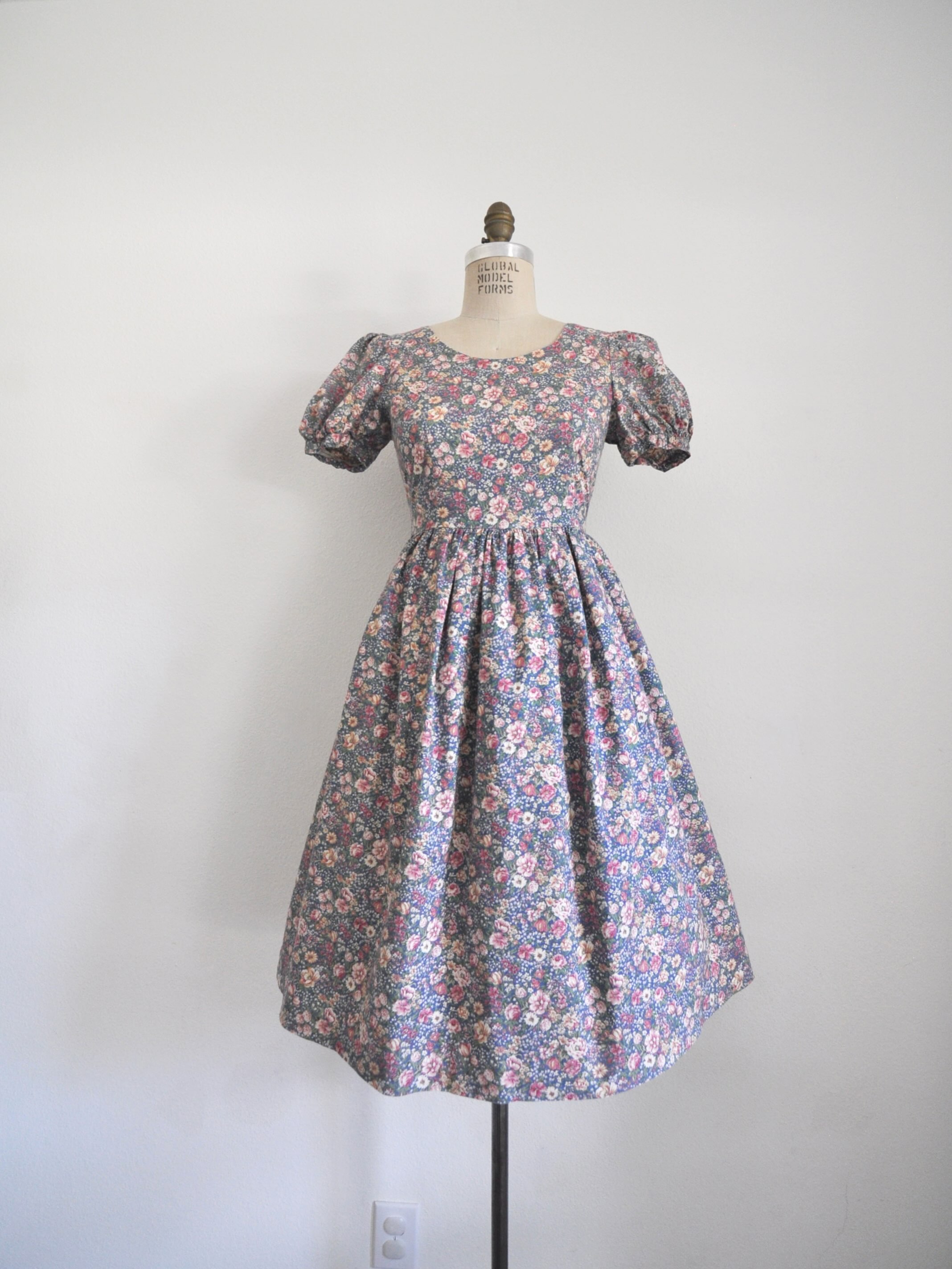 Link in bio to shop! 1990’s floral cotton dress. Back zipper, fitted waist, gathered skirt. Bust: 36” Waist: 30” Length: 40” Shoulder to waist: 14”