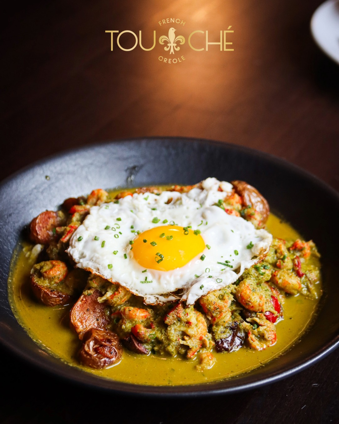 Introducing our Crawfish Hash, new on our brunch menu! Crispy potatoes, peppers, onions, and green tomato verde, piled high and topped with a sunny side up egg. Saturday and Sunday, 10 to 2, at Touché French Creole in Downtown Aurora. Reserve your table at touchefrenchcreole.com.