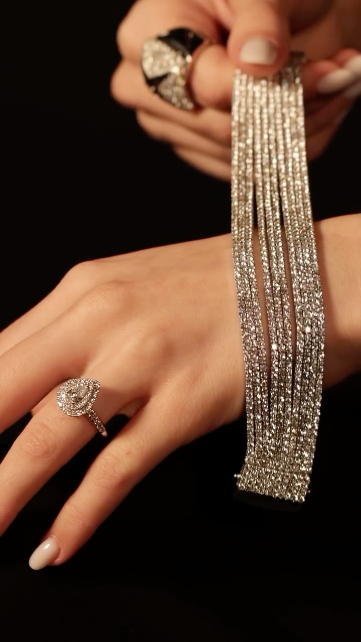 A single row of diamonds is difficult enough to execute. Every stone must match the next in colour, cut and clarity, set in a line that flexes with the wrist. Multiply that by ten and the challenge changes entirely. Ten parallel rows, each one a continuous line of matched stones, must sit in perfect alignment across the full width of the bracelet while still moving independently as the wrist bends. The rows cannot pull against each other. The stones cannot catch. From above, all ten must read as a single unbroken surface of light, while underneath, the structure has to flex like fabric. It is one of the most demanding pieces to build at this scale.
This bracelet carries 810 diamonds in F-VS quality totalling 26.80 carats, across ten rows of 18-carat white gold. A surface of diamonds wide enough to cover the wrist entirely, engineered to move as though it weighs nothing.
On the hand, a square-topped ring set with 229 brilliant-cut diamonds in F-VS at 3.58 carats, the gold beneath almost completely hidden. Beside it, a ring built around a pear-cut diamond in F-VS at 0.42 carats, framed by 52 brilliant-cut diamonds at 0.55 carats.
By private appointment only.
The BrandZ - A Luxury Experience.
#thebrandz #highJewellery #finejewellery #diamonds #diamondbracelet