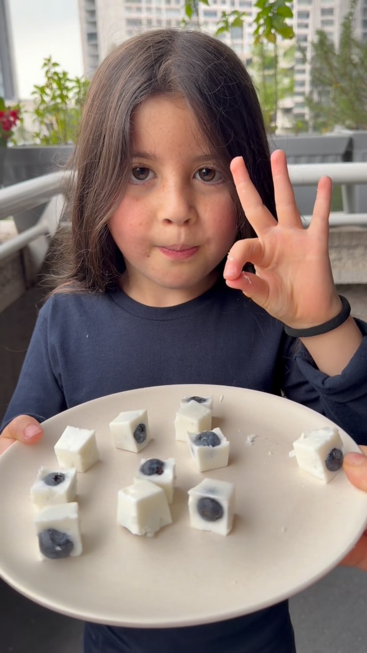 YOGURT BITES — como gomitas de yogurt, pero cremositas, frescas y con una sorpresa de blueberry en el centro.
De esas recetas que haces en 5 minutos, dejas en el refri y después desaparecen misteriosamente.
Además, es una idea padrísima para preparar con tus hijos y tener un snack fresco listo para cuando se antoja algo dulce.
Ingredientes
* 1 taza de yogurt griego
* Endulzante al gusto
* 1 sobre de grenetina sin sabor
* ½ taza de agua
* Blueberries
Preparación
1. Hidrata la grenetina en ½ taza de agua y deja reposar unos minutos. Luego calienta 25 segundos en el microondas
2. Endulza el yogurt griego a tu gusto.
3. Agrega la grenetina hidratada al yogurt y mezcla muy bien.
4. Lleva la mezcla al microondas durante 25 segundos y vuelve a mezclar hasta que la grenetina quede completamente disuelta.
5. Vierte en moldes pequeños de silicón, una hielera o el molde que tengas en casa.
6. Coloca un blueberry en el centro de cada bite.
7. Refrigera aproximadamente 3 horas, hasta que estén firmes.
8. Desmolda y disfruta.
Quedan entre gomita + cheesecake de yogurt y puedes hacer mil versiones cambiando la fruta.
Guarda esta receta para hacerla con tus hijos y mándasela a alguien que siempre está buscando snacks fáciles.