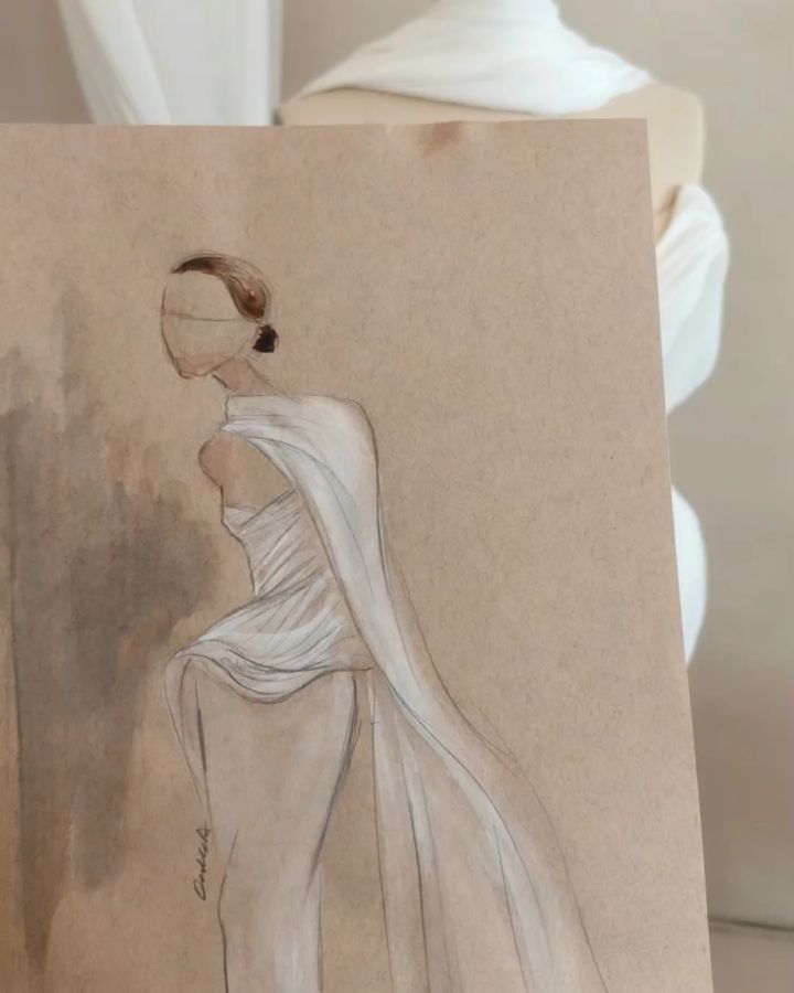 From the first line on paper to the final stitch.
Angelus began as a sketch — an idea of softness, movement, and fluidity — and slowly became the piece you see here. There’s something so special about watching a design leave the page and come to life through fabric, hands, and countless little decisions.
The journey from drawing to final design. 🤍
#OUMAAtelier #BridalFashion #CoutureBridal #ModernBridal #LuxuryBridal