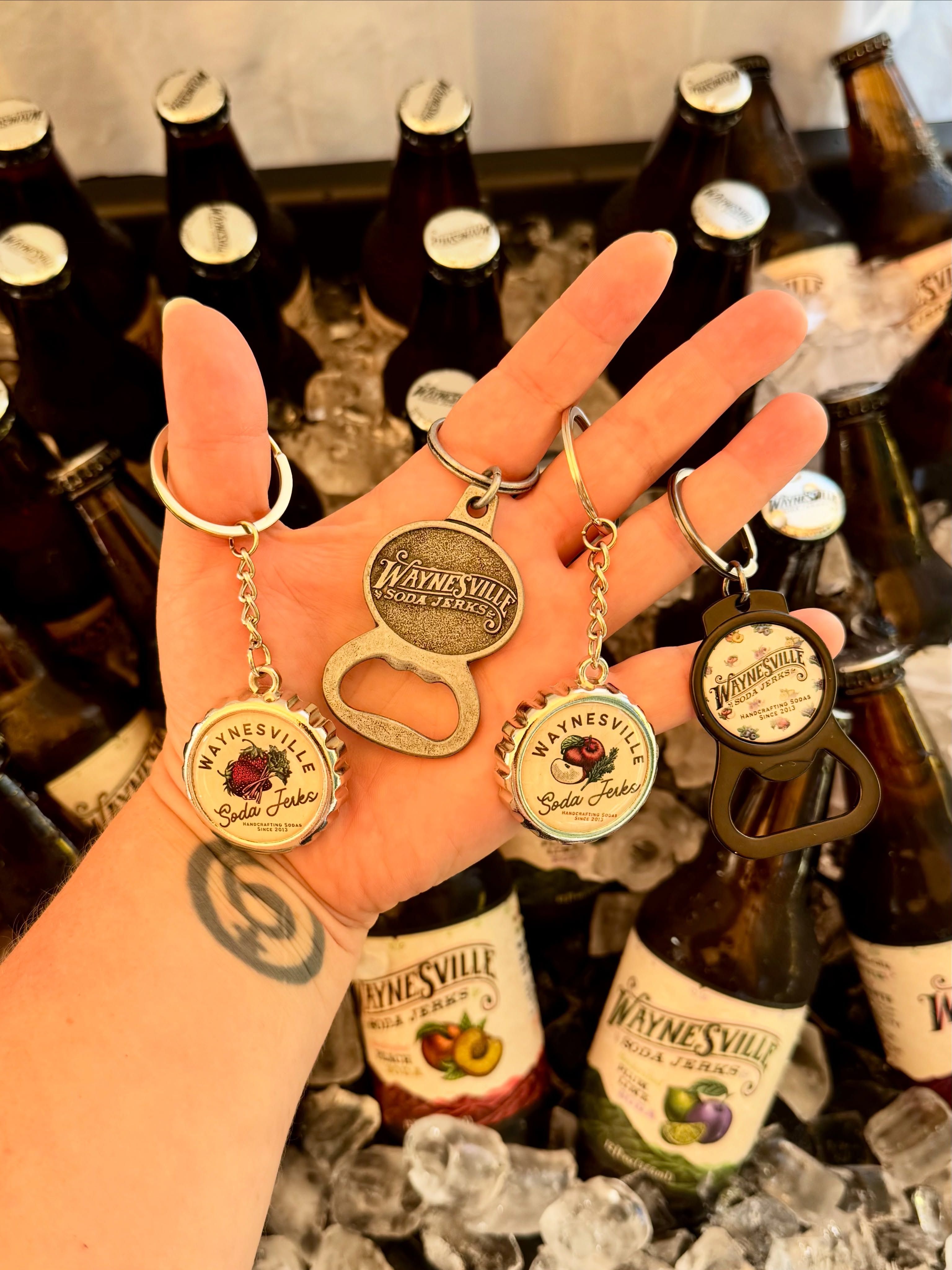 Showing off all 4 designs of our WSJ keychain bottle openers 🍾 Fun fact: our sodas use old-fashioned pry-off caps, not twist— so a good bottle opener is a must. 🤓
These are the perfect little souvenir, collectible, or everyday carry, and just as great to gift to the Soda Jerks fan in your life.
Whether you’re a bottle cap collector or just need a handy opener on the go, we’ve got a style for everyone.
Grab one in store, or add one to your online soda order and we’ll ship it right to you! 📦👋
#WaynesvilleSodaJerks #SodaJerks #WaynesvilleNC #ShopLocal #ShopSmall
