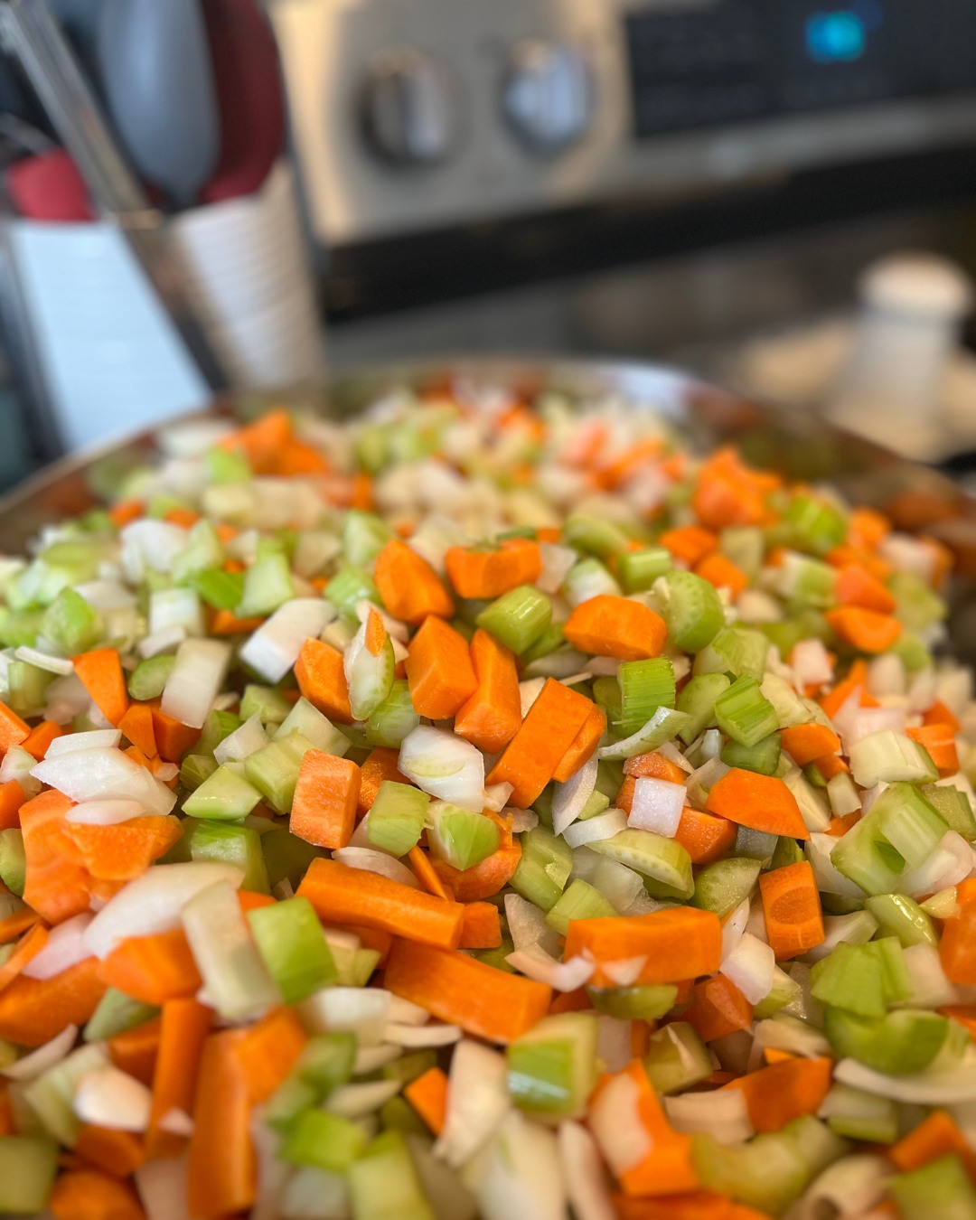 Today's the day. This started out as one of those seasonal chores, honestly - the kind of thing you just do because the freezer needs filling before winter hits. But somewhere along the way it turned into something I actually look forward to, this one afternoon where I turn a mountain of local carrots, celery, and onion (the checkout clerk always gives me a look when I show up with piles of just those three things) into the year's batch of mirepoix.
Onions get me every time. Three in and I'm half-blind, laughing at myself, wondering why I never remember how much they sting. But I've got an audiobook going and my hands just fall into the rhythm of it, and before long the counter's covered in these little piles of orange and green and white and I've forgotten all about the crying.
There's something about doing this every year that marks the season for me more than any calendar could. Summer's easing out, the Canadian harvest is at its best, and I'm standing at my counter turning it into the start of something warm. By the end of the afternoon the freezer is stacked with bags, and all winter long, a good pot of homemade soup is just a weeknight away.
I didn't always see the good in this one. Now I do. What grows here, what it becomes, what it means to have it ready when the season turns - it feels like its own quiet kind of nourishment.
