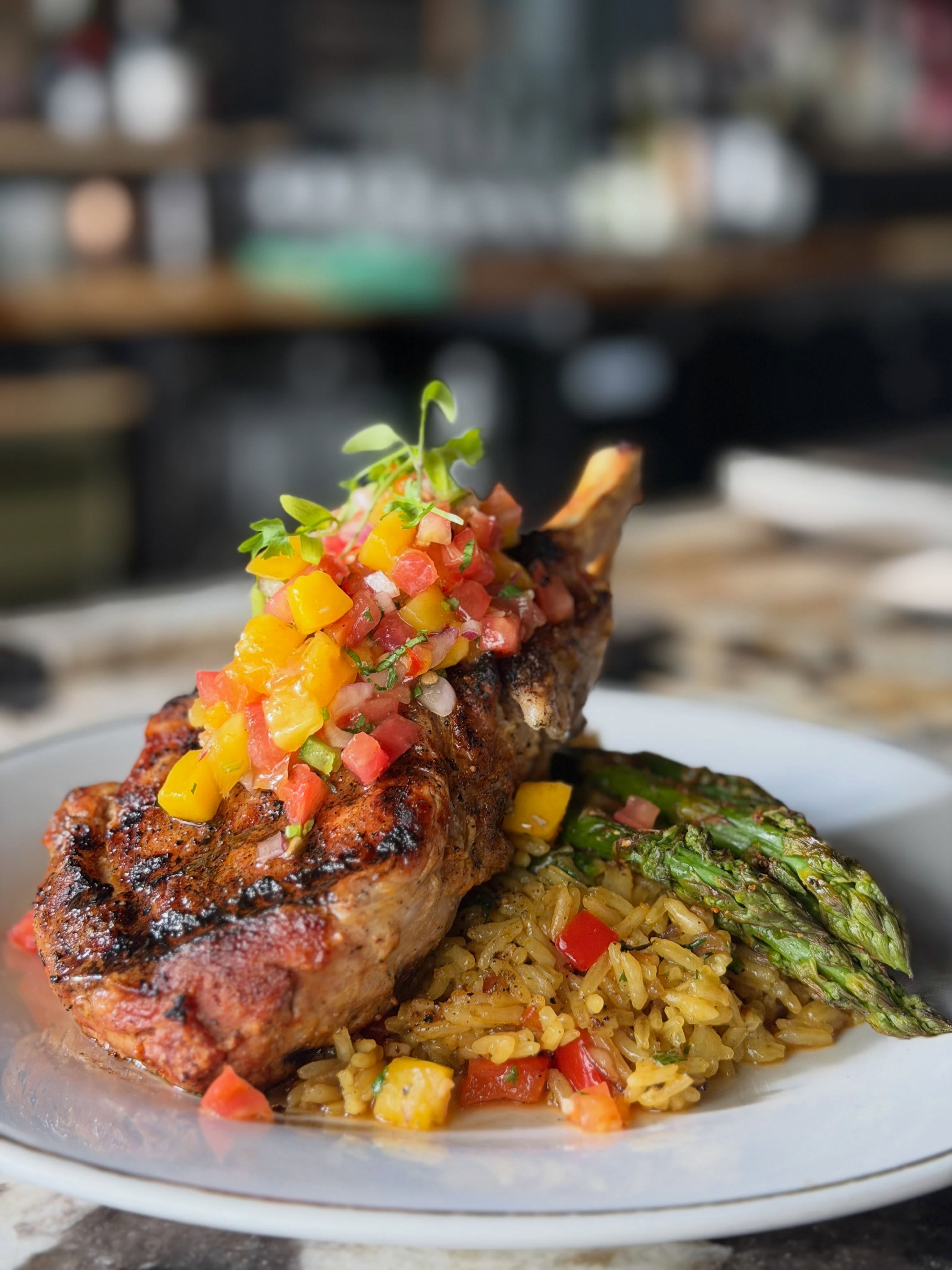 Grilled Pork ribeye, saffron rice with bell peppers & shallots, roasted asparagus & Mango salsa