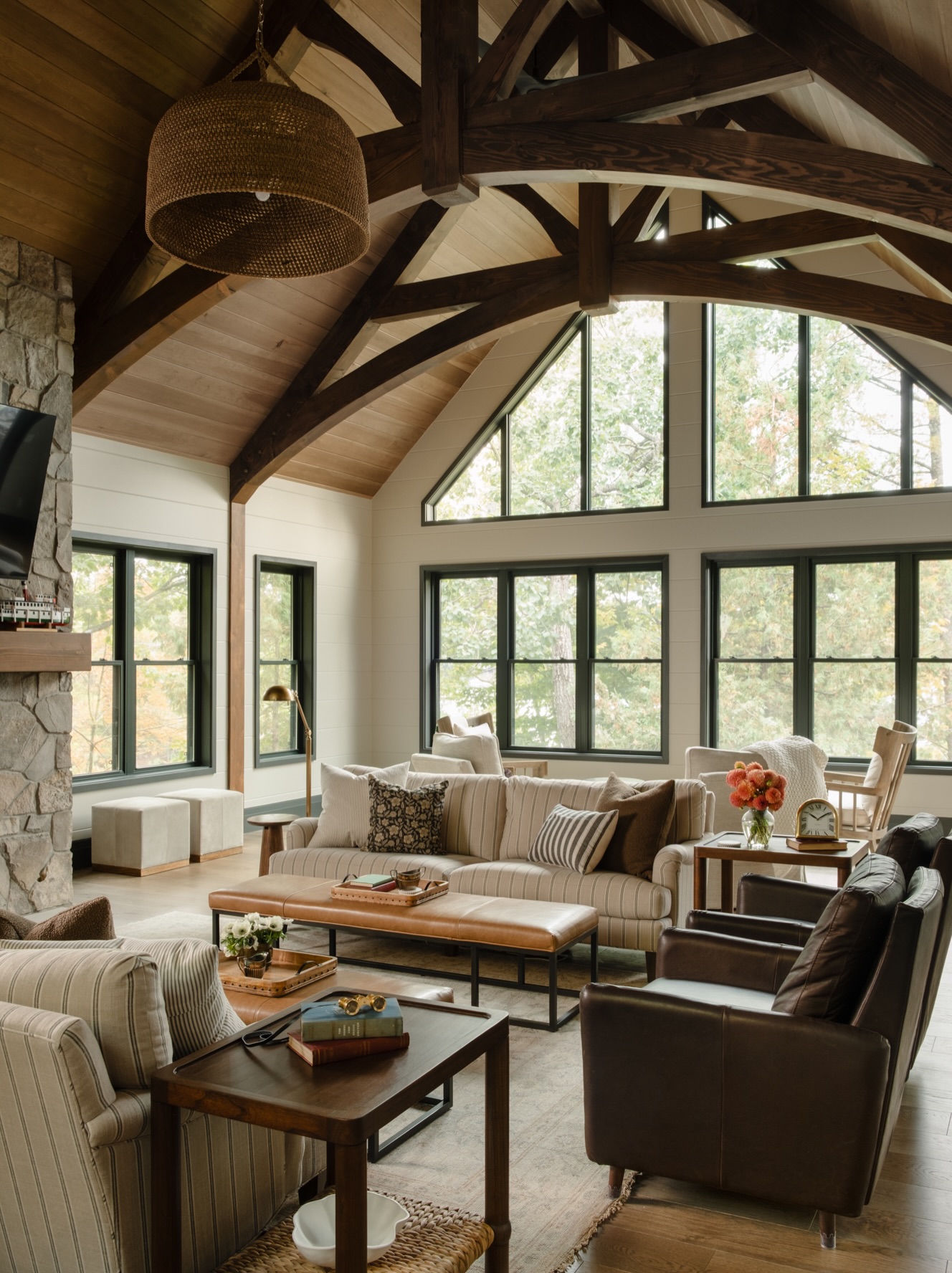 Welcome inside this custom built main floor renovation on Lake Muskoka.
#custombuild #lakemuskoka #cottagerenovation
A three season Muskoka room is now the year round hub of the house. The fireplace anchors it, with stone running floor to ceiling into the vault. Overhead, timber trusses carry the ceiling. Along the far wall, a custom bar with a hutch and wine fridge.
Follow @pattymacbuilt for more home & cottage inspiration!
Follow @spencerdouglasmuskoka for more design content and inspiration.
Interior design: @warmwelcomedesigninc