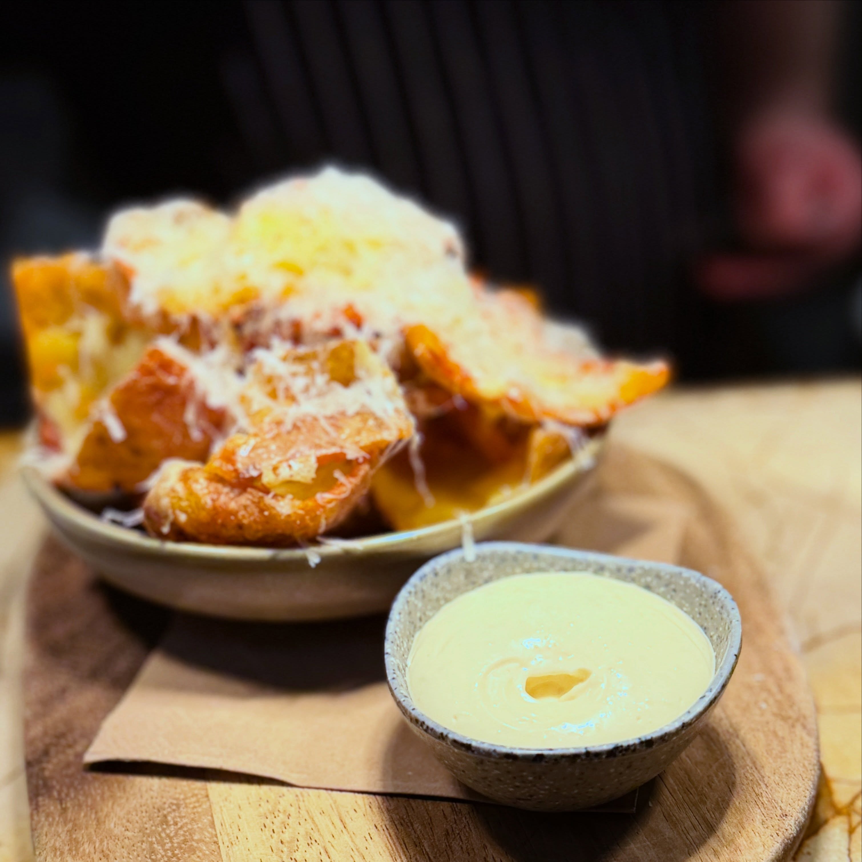 These potato skins are so elusive that the chefs won't actually make me any to get a proper photo using decent light, so I can only ever capture them fleetingly on the pass before they go to a table…
I probably shouldn't even show you a photo at all, they sell out every single day! A relatively boring by product of making gnocchi, sells out! I had to get in the way of the FOH crew to even get this terrible picture.
The potato skins even get their own google reviews.. no word of a lie. All our amazing food and these guys get a whole solo google review?
Do you know what winds me up the most about the potato skins? I have never even actually had a single one so I don’t get the hype, but you do don’t you. It’s always the first question from the early tables.. “did we get here early enough for the skins?” At 5pm!!!
Obsessed, all of you 🤷♀️ over potato and cheese.. go figure..