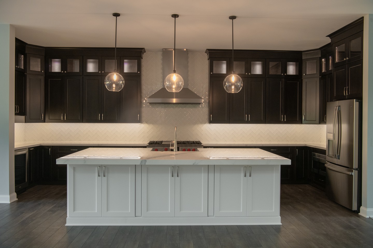 Set the Mood Before Dinner Even Begins
There’s something about a beautifully lit kitchen at the end of the day. Warm pendant lights, softly illuminated cabinetry, and a dramatic contrast of dark cabinets against a bright island create an atmosphere made for everything from quiet dinners to evenings filled with family and friends.
When you build custom, even the lighting becomes part of your story. 🏡✨
