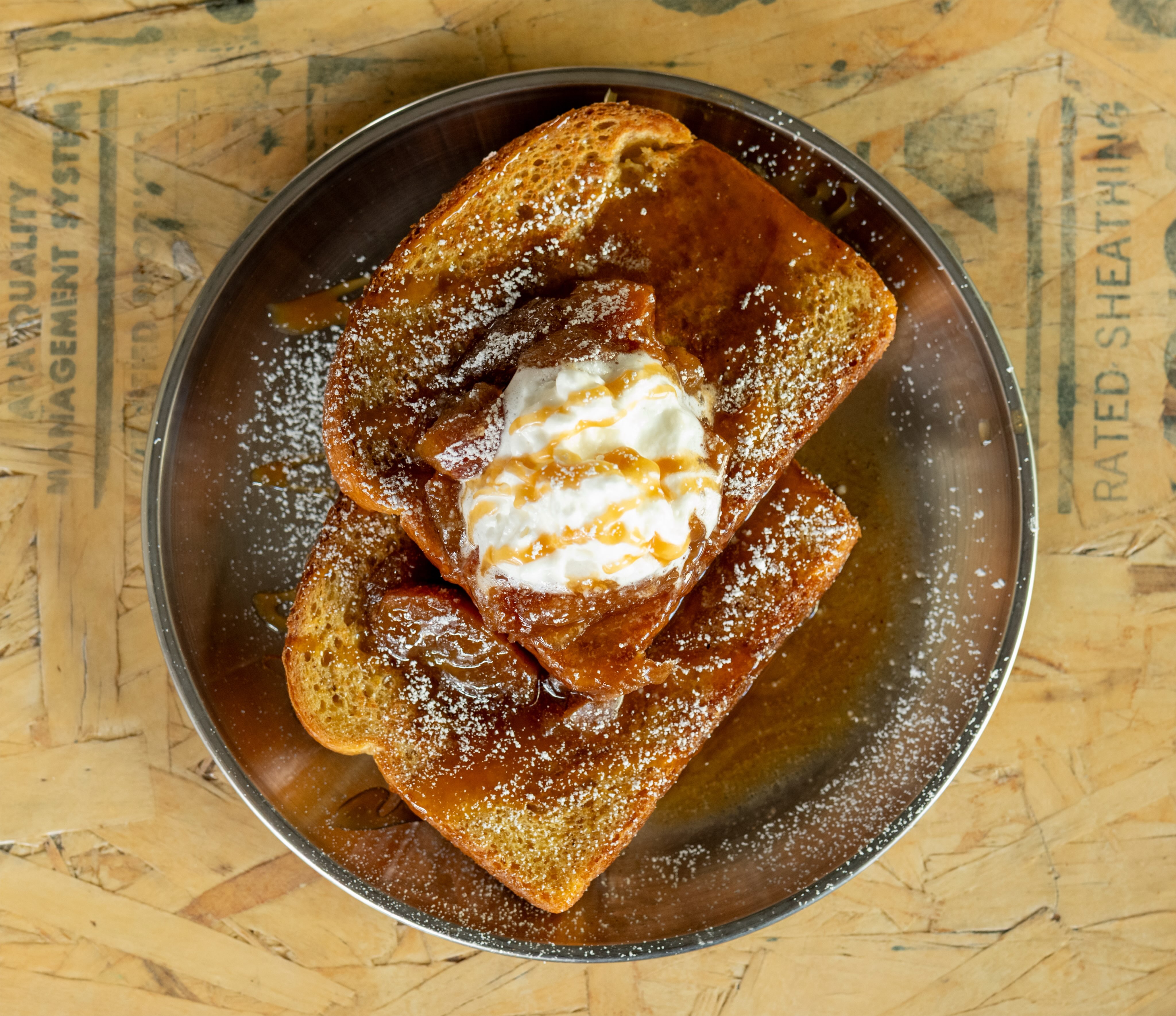 Two pieces of French toast topped with warm cinnamon apples, caramel drizzle, powdered sugar and whipped cream. 🤤🤤🤤🤤🤤🤤