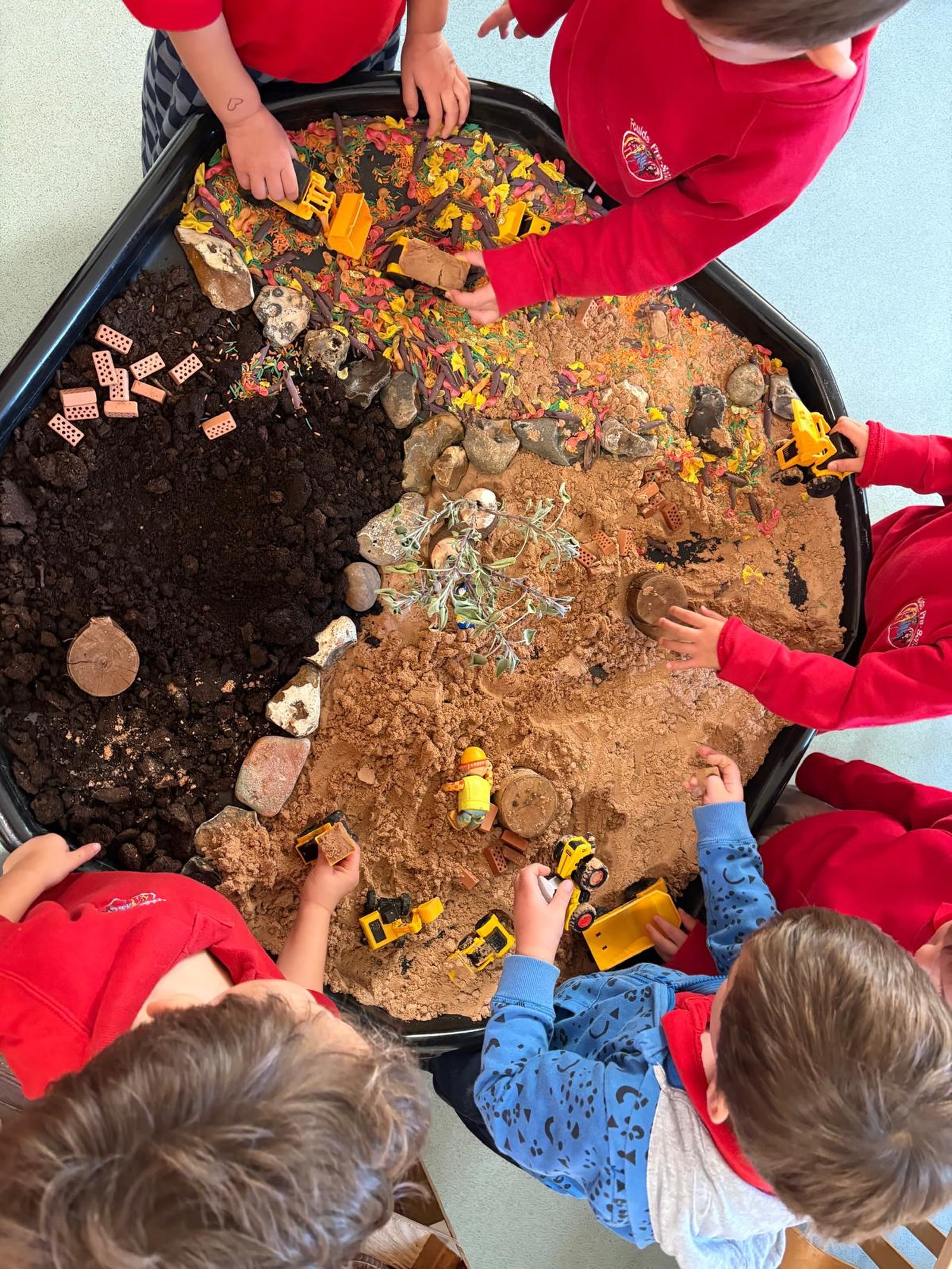Every year, we have a group of budding builders who can’t wait to get their hands on the diggers and get to work in our tuff tray construction site. And every year, we try to up the ante!
This year we’ve got sand for digging, rocks for hauling, leaves for landscaping, Lego for building those all-important structures, we’ve got a tree and we’ve even got a designated area for the diggers to park at the end of a hard day’s work!
There does appear to be a small health and safety issue with a poor chap face down in the sand…but we’re sure he’s completely fine and not overworked to exhaustion 😂
It’s wonderful to see the children so engaged in their play, collaborating to bring their vision to life. The problem-solving, communication and creativity going on here is all serious learning disguised as fun!
#fouldspreschool #constructionplay #tufftray #learningthroughplay #earlyengineering