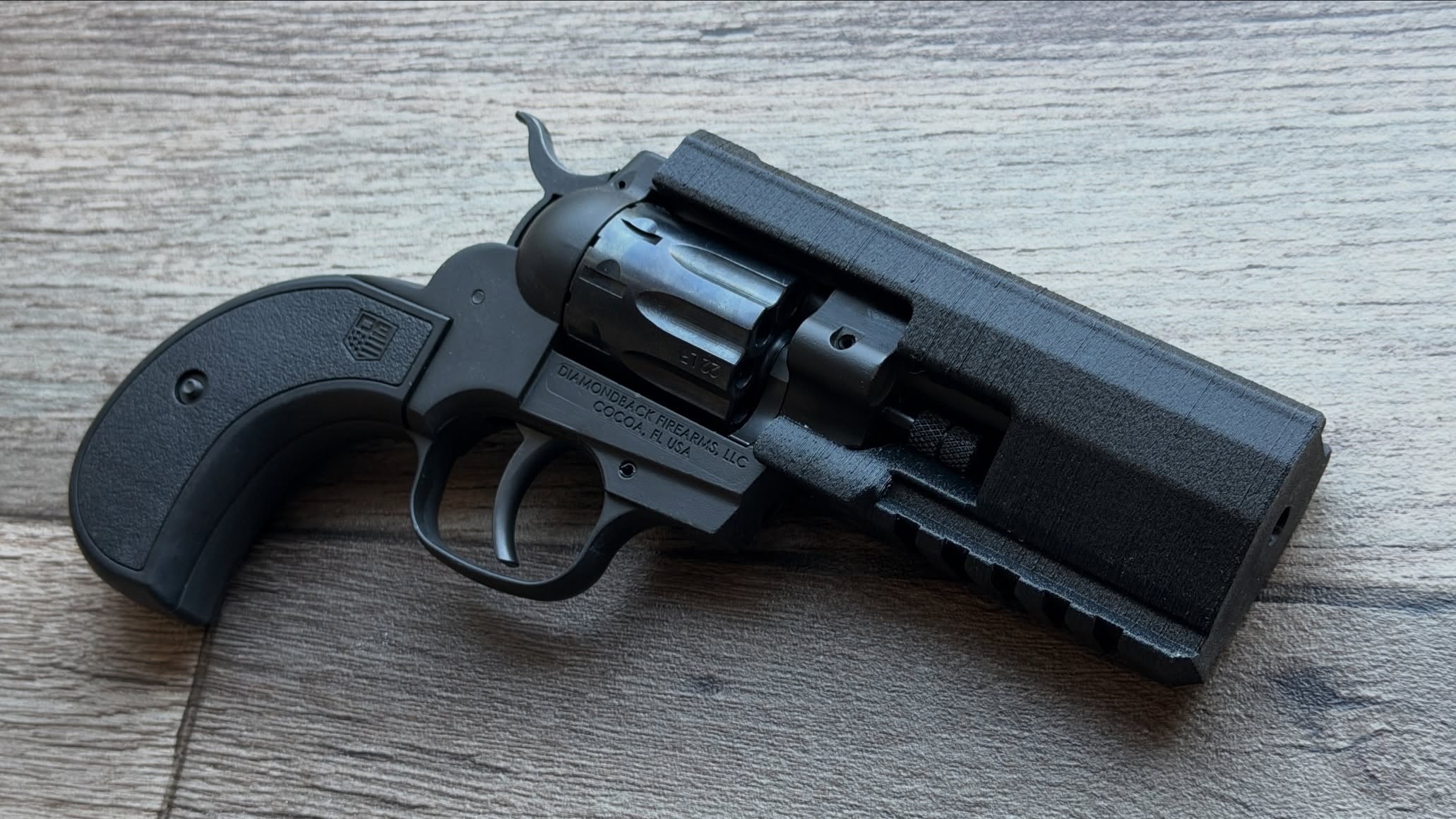 Quick and dirty prototype print. My fuzzy skin settings went… off. But here’s a modular barrel sleeve for the short barreled @dbfirearms Sidekick. This is the most stripped down version, just with iron sights and a built in big port because it’s fun to shoot ported .22 WMR guns.
The short barreled version doesn’t have the faux ejector rod that releases the swing out cylinder, instead requiring you to slide the cylinder axle itself forward to release the cylinder. I designed this to accommodate it and it’s very easy to manipulate the axle, but since there’s no existing mounting screw, this does require one hole to be drilled and tapped to secure the kit to the barrel. Easy peasy.
Other configurations will be shown shortly, this one has some neat features!