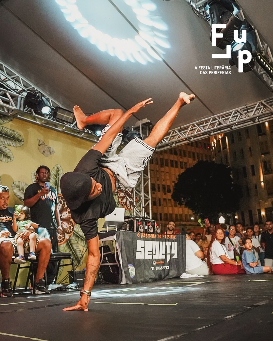 A Flup 26 acabou e vai deixar saudades! Teve encontros, festas e tudo que deixa a festa ainda mais linda.
A Flup agradece por cada sorriso, por cada momento lindo! No último dia tivemos variasssss finais: teve Slam Colegial, Batalha de Esquetes, Barbeiro, Altinha e muito mais.
Foram dias de ocupar as ruas, celebrar a literatura das periferias e lembrar que a nossa voz ecoa longe.
As filhas, das filhas, das filhas seguem sonhando, e a gente já começa a contar os dias para o próximo encontro. Até a Flup 27! 💛
A 16ª FLUP é apresentada pelo Ministério da Cultura, Prefeitura da Cidade do Rio de Janeiro, Secretaria de Cultura e Shell. Tem patrocínio master da Shell por meio da Lei Federal de Incentivo à Cultura, patrocínio da Prefeitura da Cidade do Rio de Janeiro e Secretaria de Cultura, por meio da Lei Municipal de Incentivo à Cultura - Lei do ISS, e Secretaria Municipal de Educação. O apoio é da Fundação Ford, Imaginable Futures, Instituto Ibirapitanga, Hawthornden Foundation, Fundação Itaú e British Council. A parceria é da Embaixada da França. Realização: Suave, Associação Na Nave e Ministério da Cultura.
De 16 a 27 de setembro, o Rio recebe a primeira edição da Semana de Arte do Rio.
Serão 12 dias de programação, reunindo festivais, exposições, intervenções urbanas e atividades de diferentes linguagens artísticas em espaços culturais, museus, teatros, galerias e equipamentos públicos da região central.
Uma plataforma que conecta arte, cultura, cidade e economia, fortalecendo o Rio como referência na produção artística contemporânea.