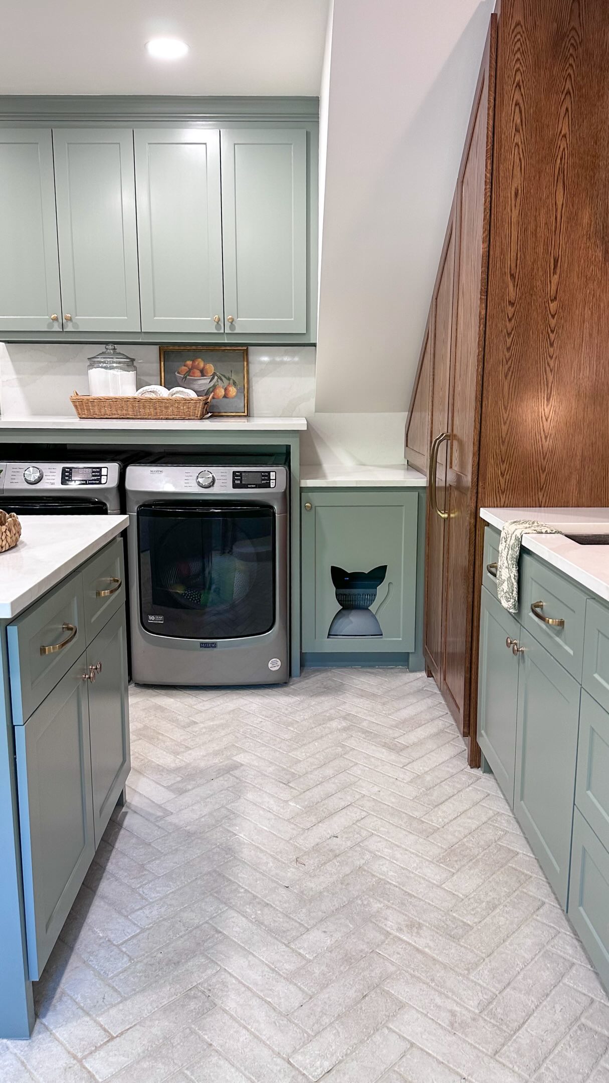 The things we do for our clients… including the four-legged ones. 😂🐈⬛
We hid our client’s cat’s litter box inside the cabinetry and gave her the cutest little cat cutout to come in and out as she pleases. No litter box sitting out, no litter getting kicked halfway across the laundry room, and the days of constantly sweeping it up are officially OVER. 🙌🏻
As for the rest of the laundry room, our client wanted it to feel fun, colorful, and function for her everyday life. She loves green, so we went with Acacia Haze on the cabinets, a herringbone paver floor, and LOTS of functional storage to keep everything tucked away.
But I fear the cat door still wins. 😂
Keep this one in your back pocket for your future laundry room reno… your cat will thank you.
And if you love design ideas you’ll actually want to steal for your own home…stick around. We have plenty more where this came from. 😎
Who else NEEDS this upgrade in their home?!
•
•
•
Construction by @brnalba