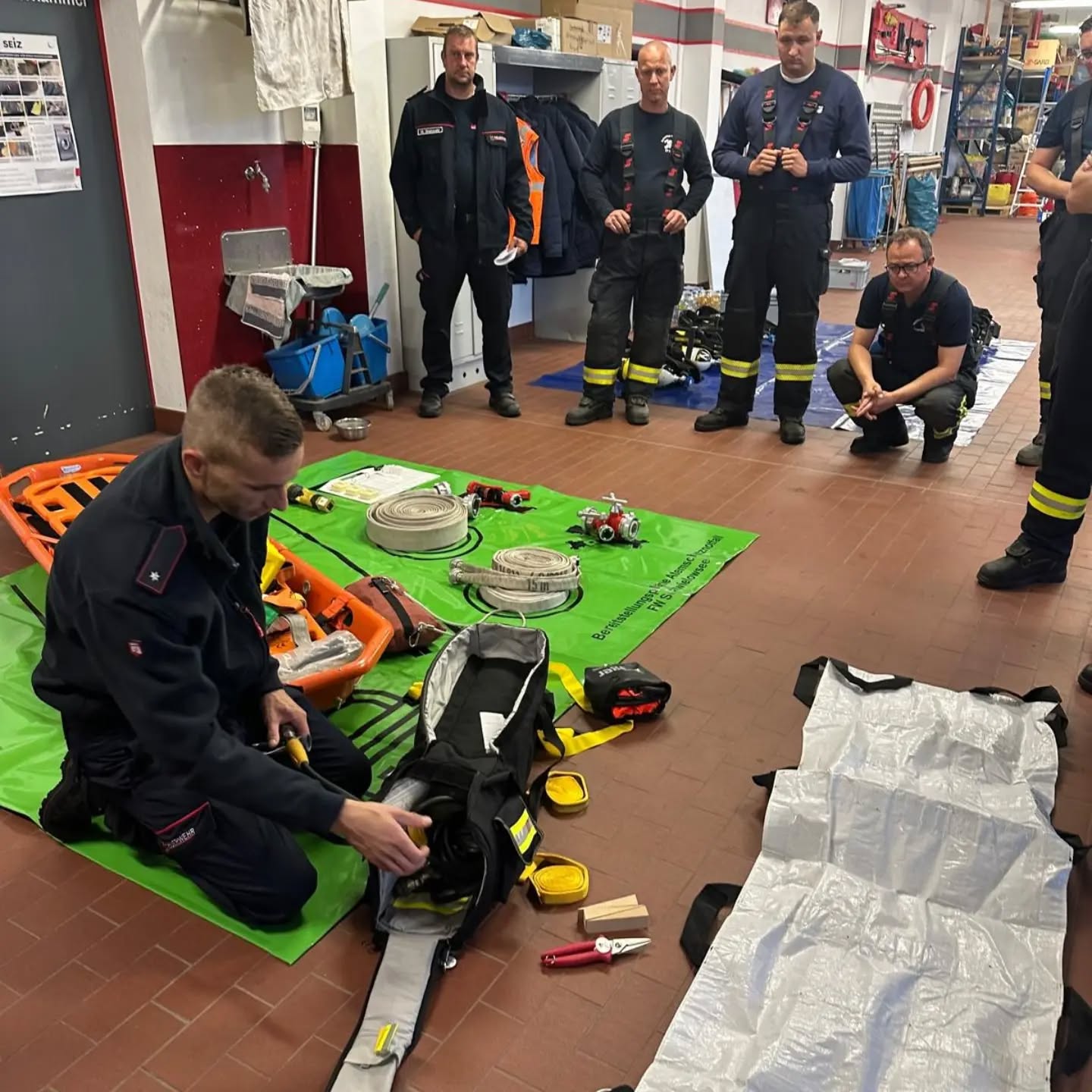 🚒 Freitagsausbildung bei der Freiwilligen Feuerwehr Lehnin
❓ Was ist zu tun, wenn ein Atemschutzgeräteträger im Einsatz in eine Notlage gerät und über Funk dreimal „Mayday, Mayday, Mayday“ absetzt? 🆘💨 Genau mit diesem Szenario beschäftigten wir uns bei unserer heutigen Atemschutz-Notfallausbildung.
Zwei Kameraden der Freiwilligen Feuerwehr Caputh aus der Gemeinde Schwielowsee waren unserer Einladung gefolgt, um mit uns wichtige Handgriffe, Abläufe und Maßnahmen für den Atemschutznotfall zu trainieren. 💪🧑🚒
Zunächst wurden verschiedene Gerätschaften vorgestellt und erläutert, welche Ausrüstung sich in einer Atemschutz-Notfalltasche befindet und wie diese im Ernstfall eingesetzt wird. 🎒🧯🔧
🚨 Dann ging es in die praktische Ausbildung: Drei Atemschutzgeräteträger bildeten den Sicherungstrupp und übten unter Atemschutz die Rettung eines in Not geratenen Kameraden, der ebenfalls mit einem Pressluftatmer (PA) ausgerüstet war. Dabei standen das richtige Vorgehen und das sichere Zusammenspiel im Atemschutznotfall im Mittelpunkt. 🆘👨🚒
Auch unsere zukünftigen Atemschutzgeräteträger konnten praktische Erfahrungen sammeln. Sie führten eine Kurzprüfung der PA-Geräte durch und übten das richtige Aufsetzen und Tragen der Atemschutzgeräte. So bekamen sie einen ersten Eindruck davon, wie es ist, sich mit einem Atemschutzgerät zu bewegen. 🫁🔧
Zum Abschluss wurden das An- und Abkuppeln am PA-Gerät sowie das Ein- und Ausrollen von Schläuchen ohne Atemluft praktisch geübt. 🌀🚒
💪🔥 Praxisnah trainieren, um im Atemschutznotfall schnell, sicher und richtig handeln zu können!
🙏 Ein großes Dankeschön an unsere beiden Kameraden der Freiwilligen Feuerwehr Caputh für die Vorbereitung, die Durchführung und die lehrreiche Ausbildung! Vielen Dank, dass ihr unserer Einladung gefolgt seid und euer Wissen und eure Erfahrungen mit uns geteilt habt.
Bei aller Ernsthaftigkeit und der nötigen Konzentration kam natürlich auch der Spaß nicht zu kurz! 💪😄🚒
#FeuerwehrLehnin #FeuerwehrCaputh #Atemschutz #Atemschutznotfall #FeuerwehrAusbildung