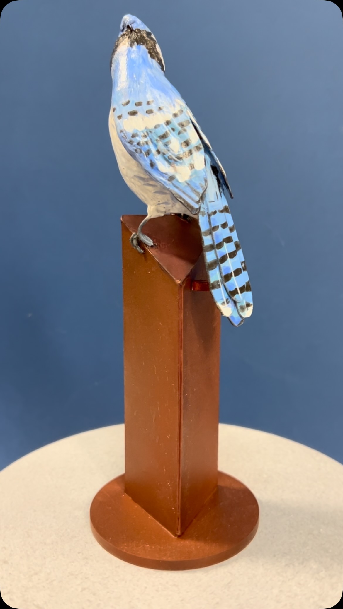 Model of the 5’ tall sculpture for my Mom, Judy Geller. The bird is a little bit thinner and not exactly positioned on the post where she will be in the final piece, but I make models to work out a few of the kinks and be able to start measuring and creating.” A Blue Jay tribute for Judy Geller” will be a public art project in part funded by the public… maybe you? I will be creating this sculpture made of steel and concrete and ceramic that will find its home at the Bear Creek Nature Center in Colorado Springs or possibly someplace in the town of Manitou Springs where my mother has lived over 40 years and was an adored member of the community. It will find its home by the end of June, 2027. Fabrication will begin in the coming months. Contribute if you can. www.go fund.me/kristine-mint-31aug. Thank you. fly my sweet mama home. #ArtAndEnvironments #GoFundMe #ABlueJayTributeForJudyGeller #communityPublicArt.